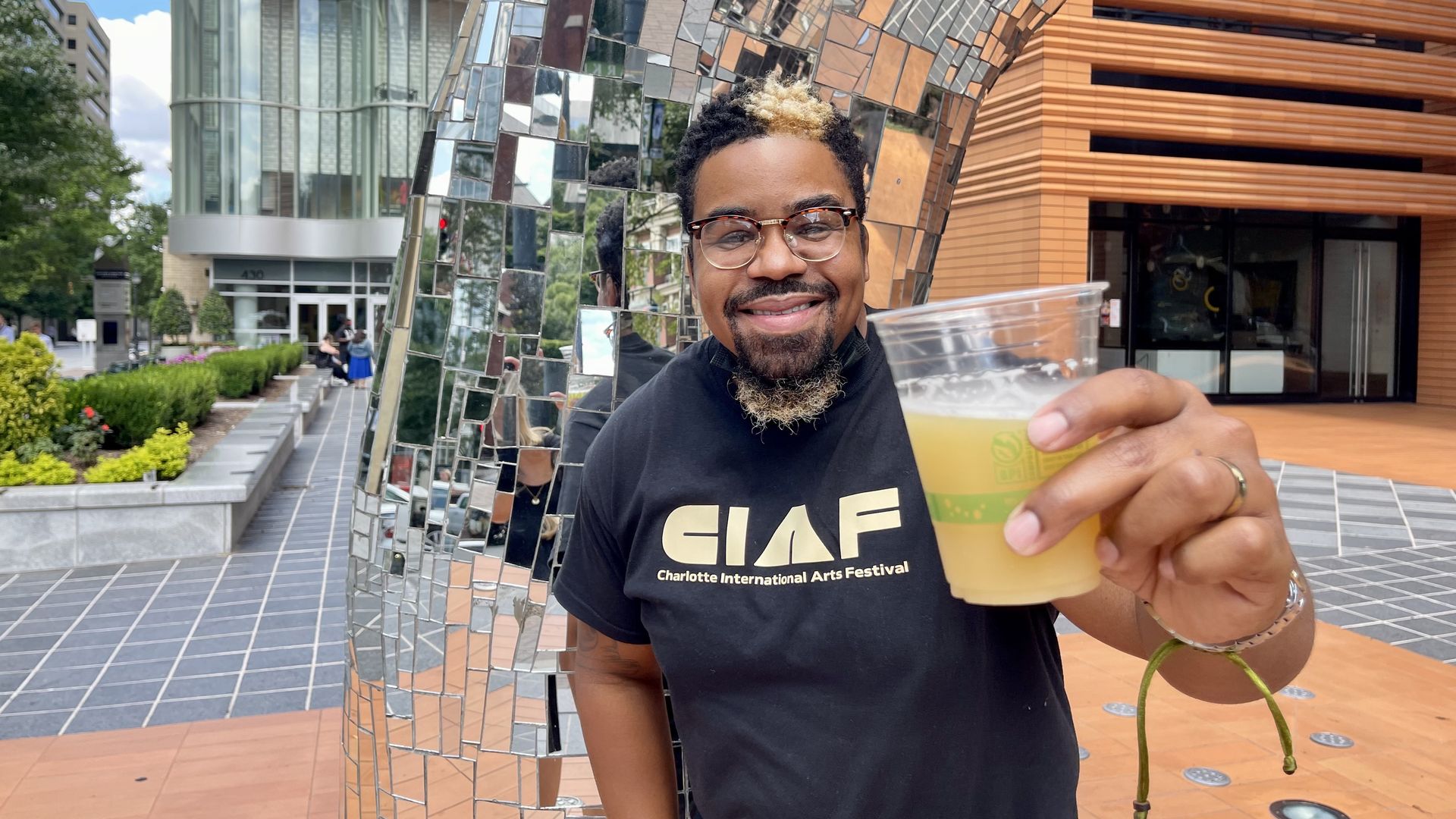 A man holds up a beer