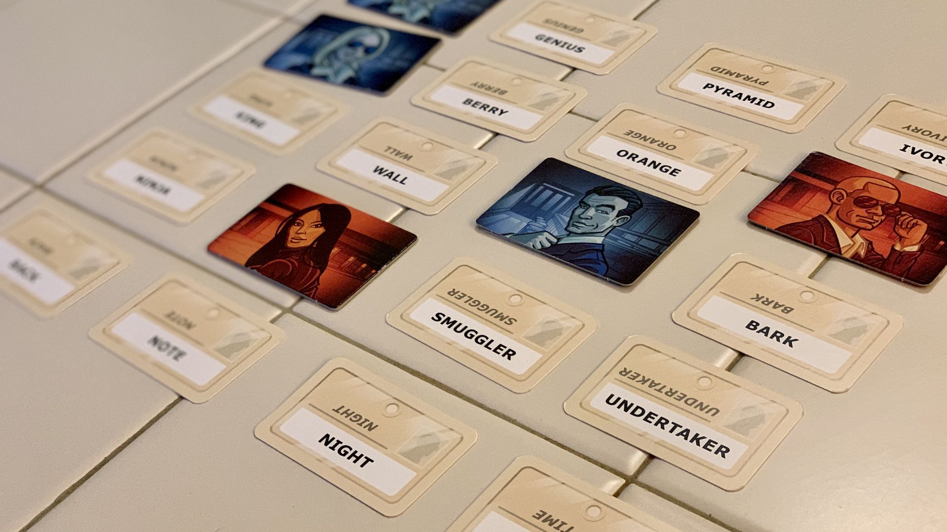 Photo of a game board with a grid of 25 words, some covered by cards