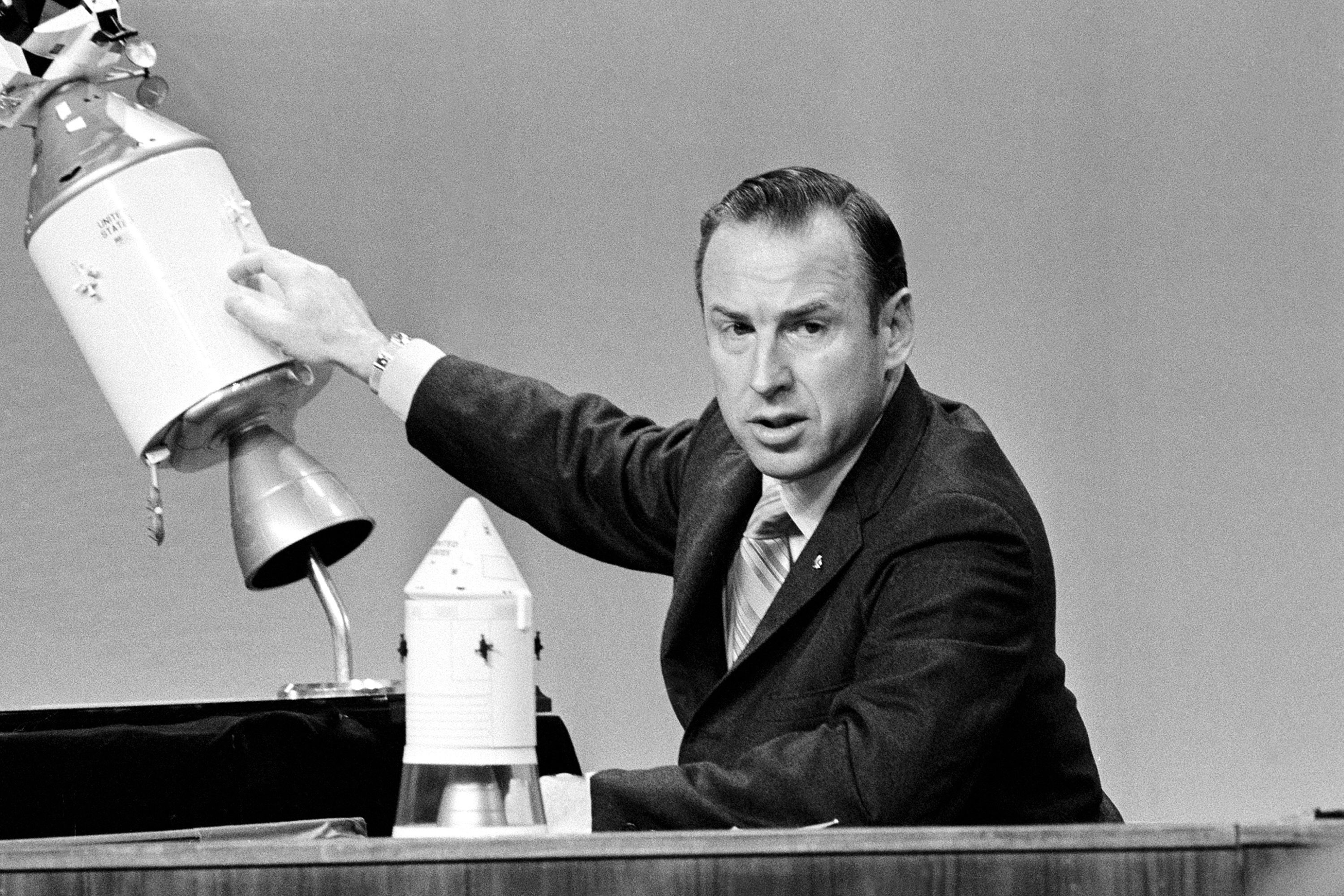 Lovell points to a spacecraft model