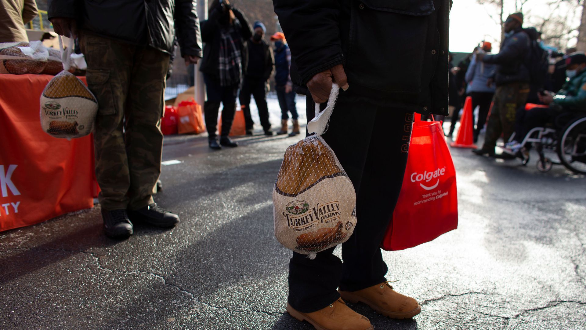 A person holds a packaged turkey in one hand.