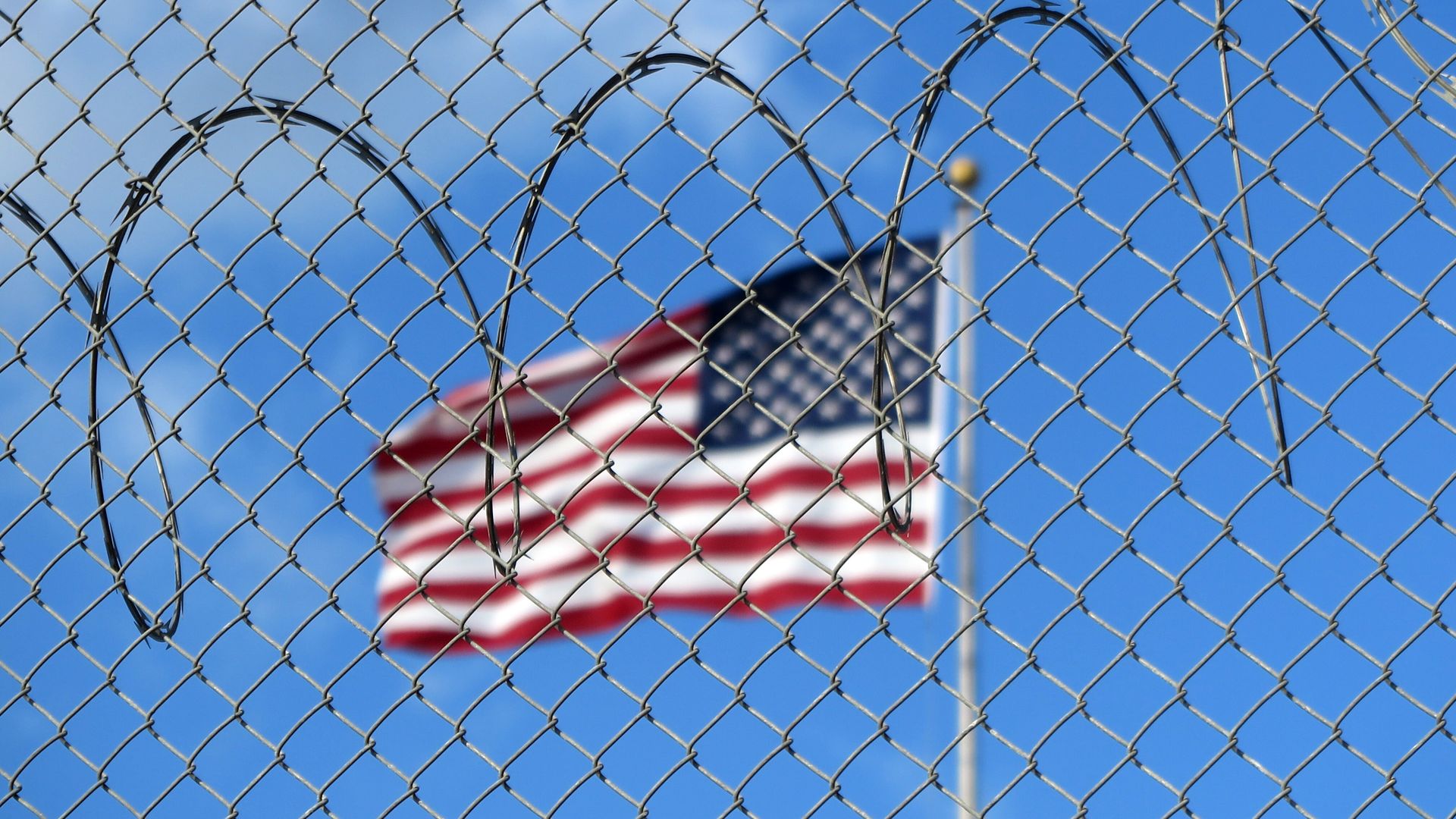 A U.S. flag flies behind barbed wire at the Guantánamo Bay naval base in Cuba.