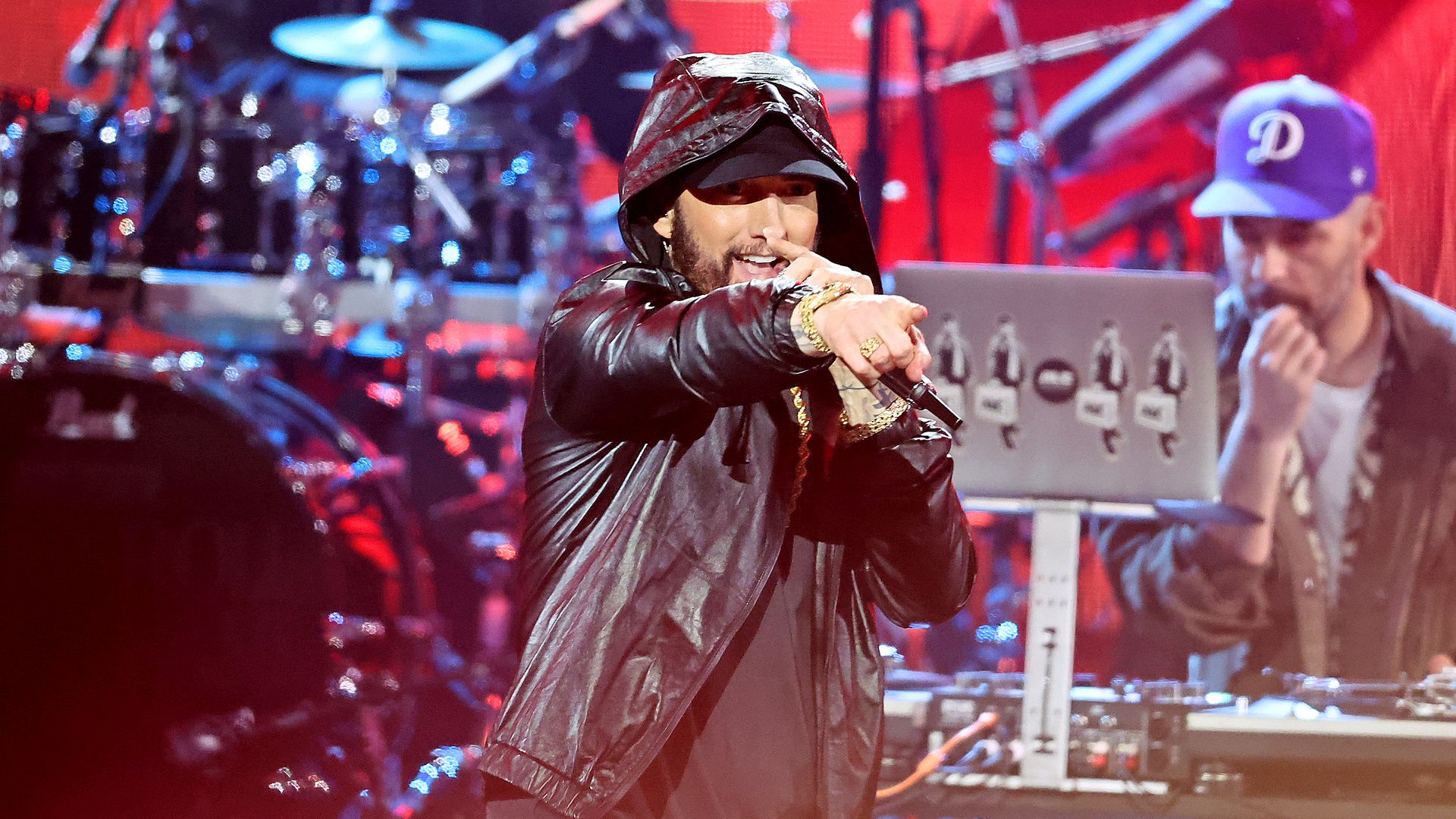 Eminem performs ons tage in a black hoodie and hat. 