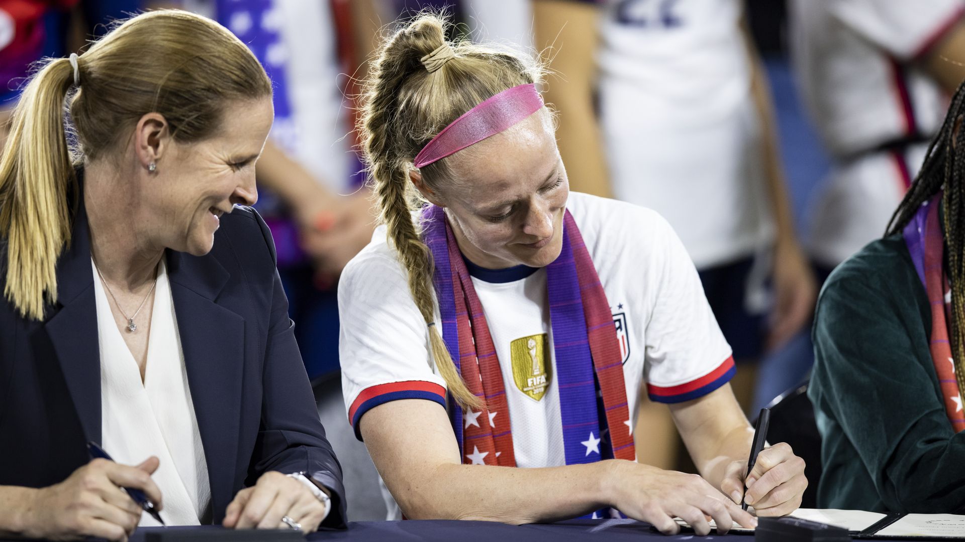 Becky Sauerbrunn #4 of United States wears an Equal Pay scarf signs the historic collective bargaining agreement.
