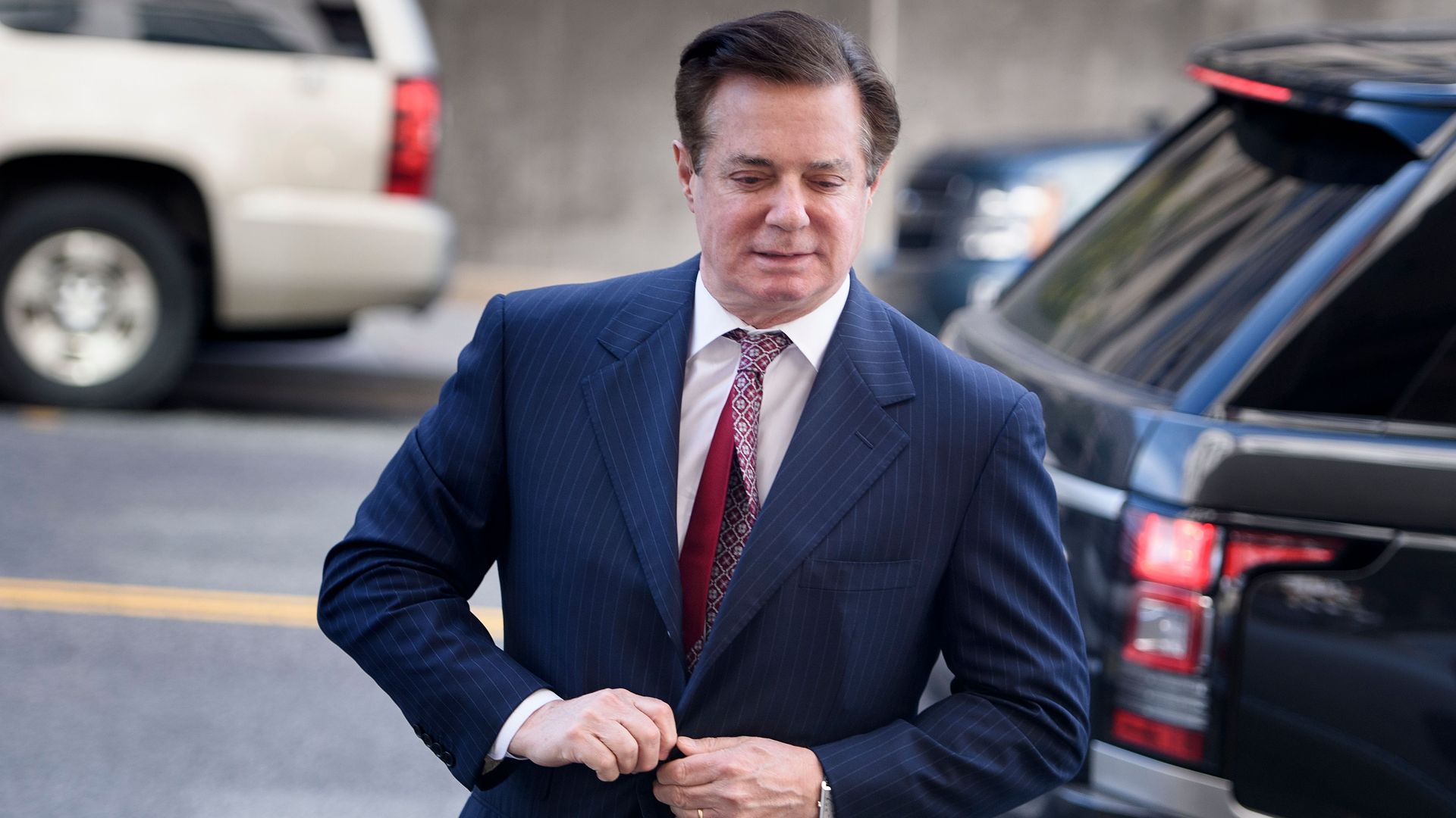 Paul Manafort buttons up his jacket as he walks toward the courthouse