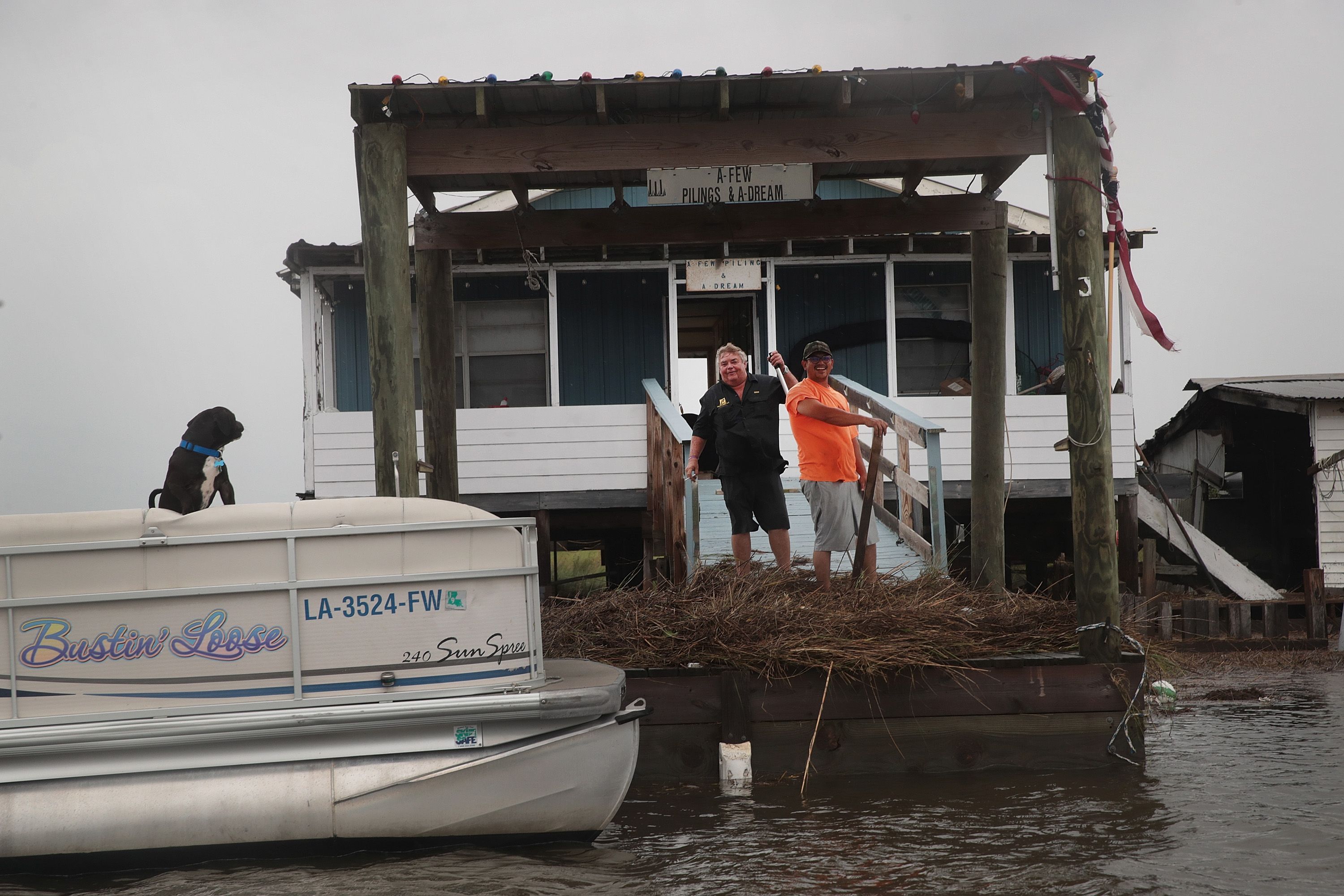 Residents repair damage to their fish camp following Hurricane Barry on July 14.