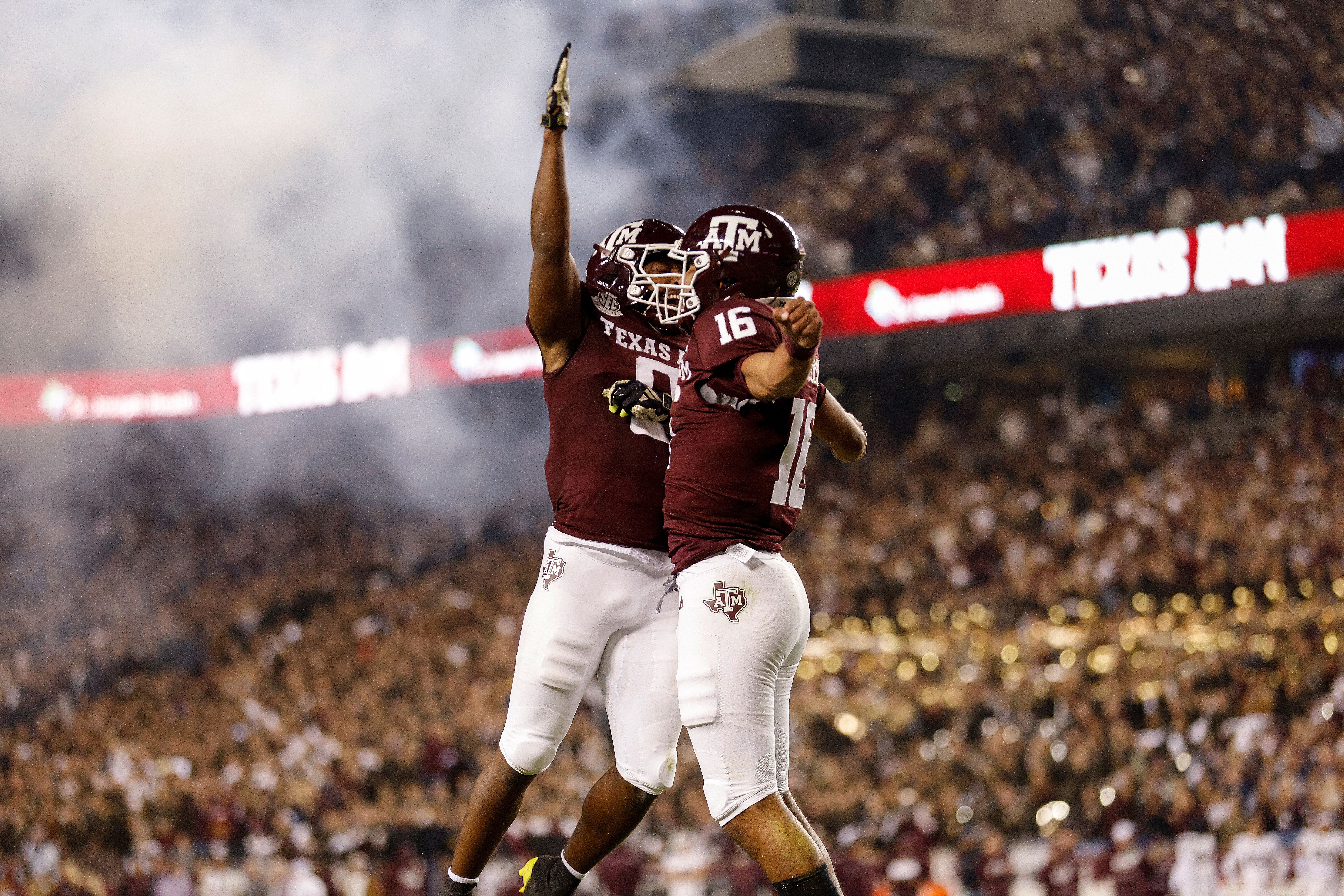 Texas A&M football players celebrate on the field. 