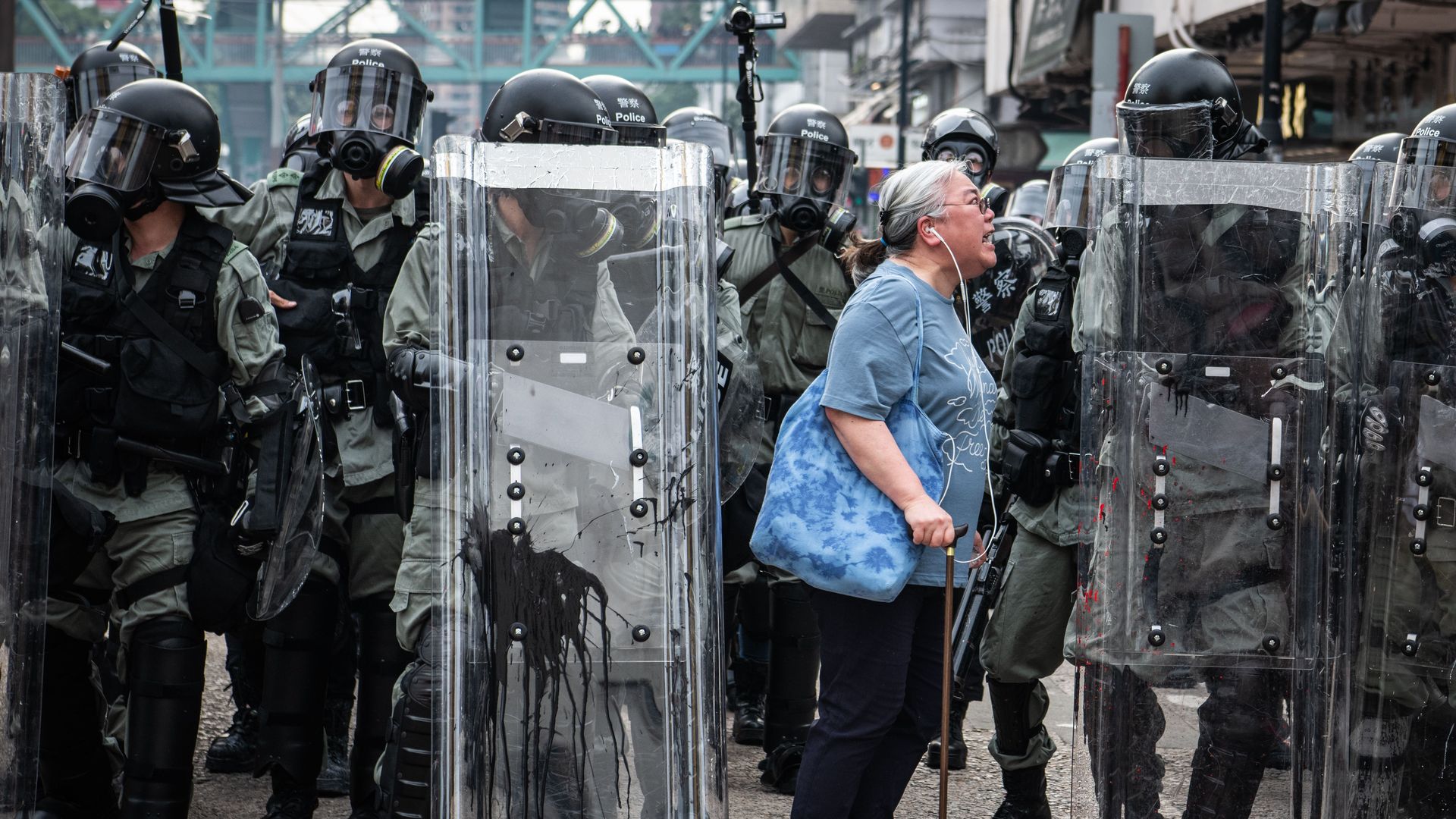 A woman screams at riot police