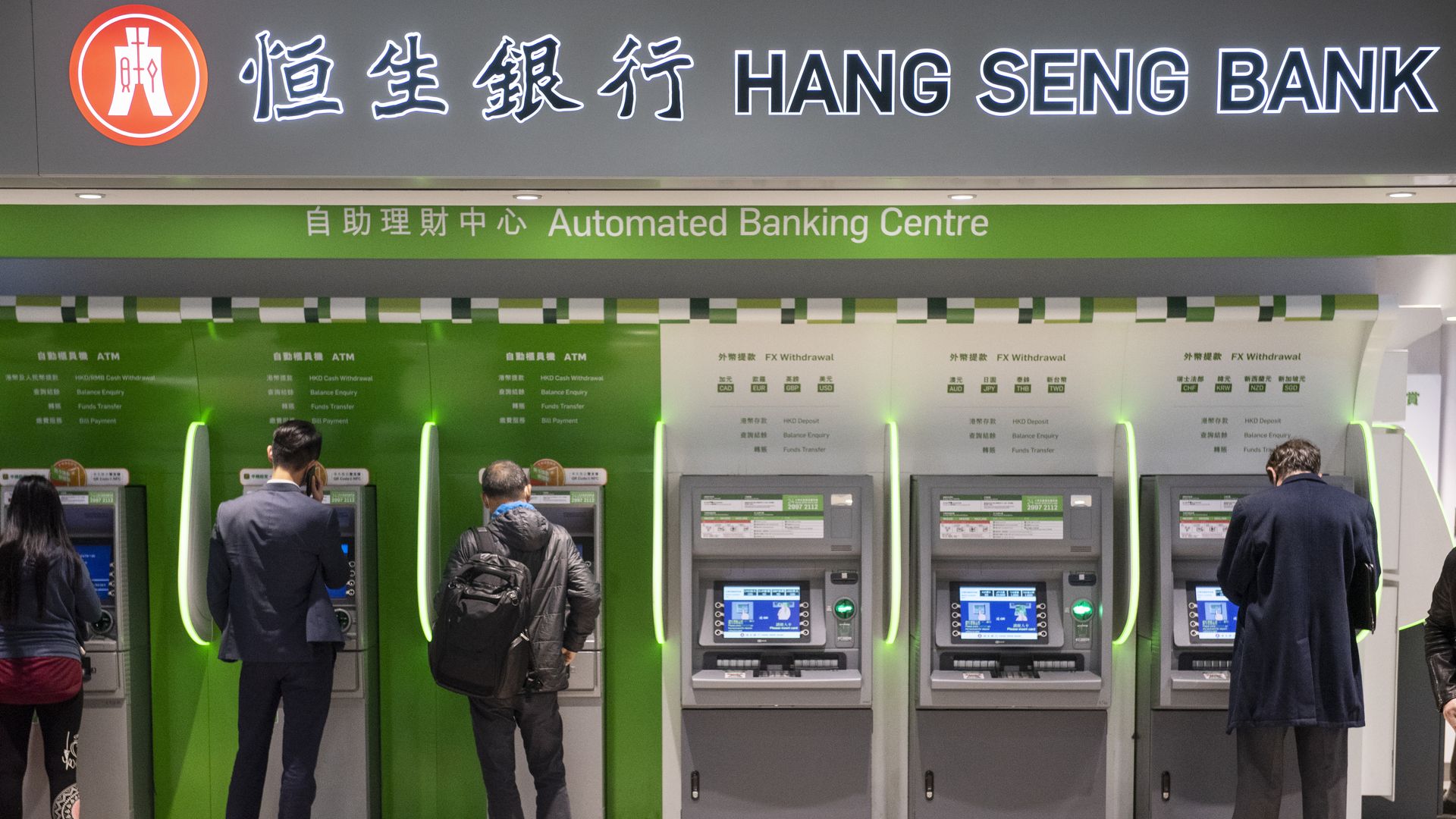 Clients withdraw money from a Hang Seng Bank ATM in Central MTR subway in Hong Kong.