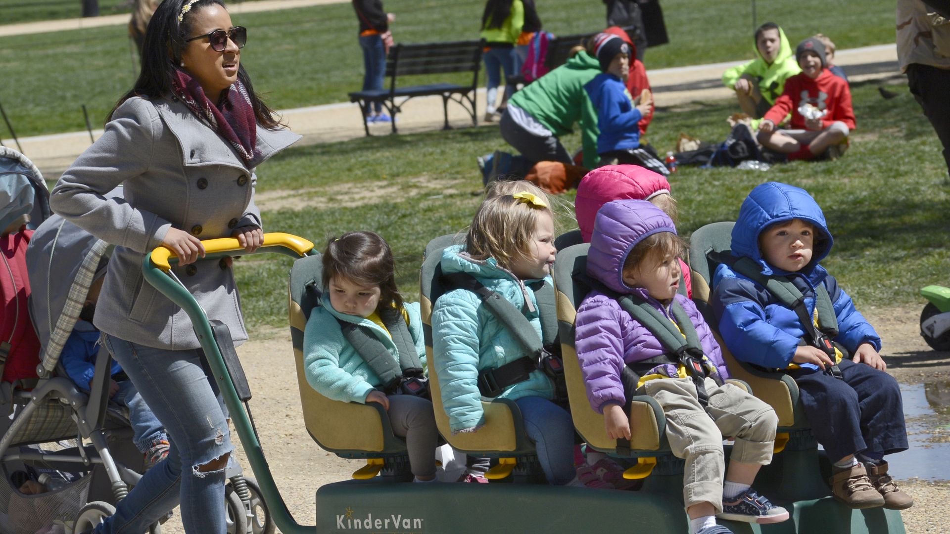 Daycare worker pushing a trolley of kids