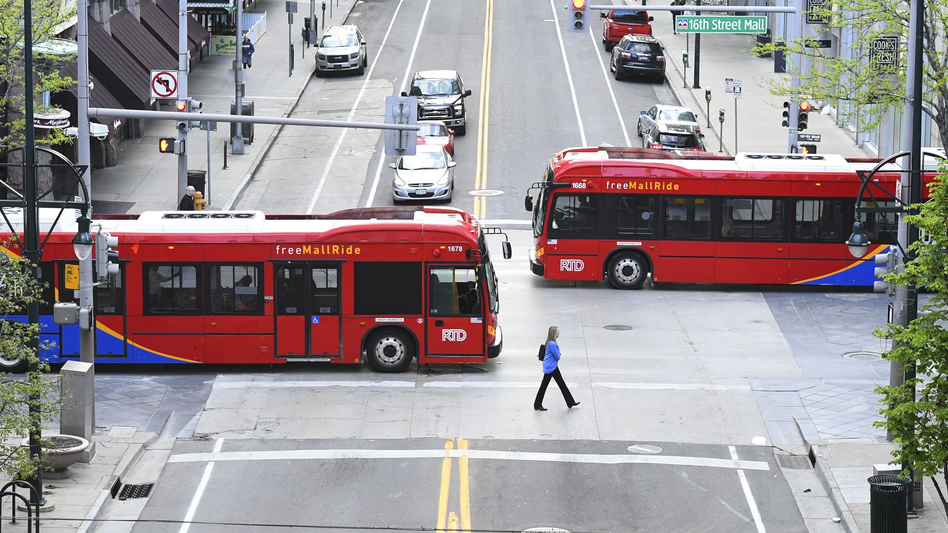 A photo of busses crossing an intersection.