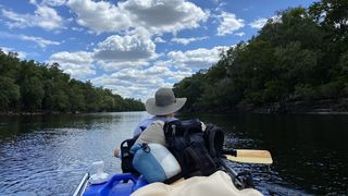person canoeing on river
