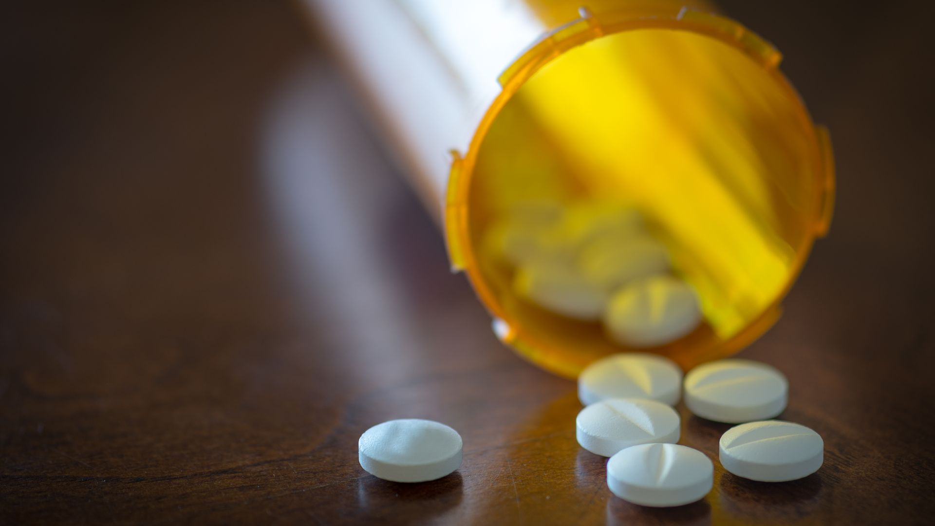 Prescription drugs spilling out of a bottle
