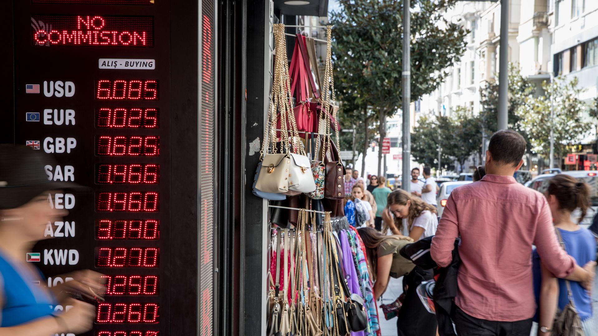 People walk by a currency exchange in Turkey