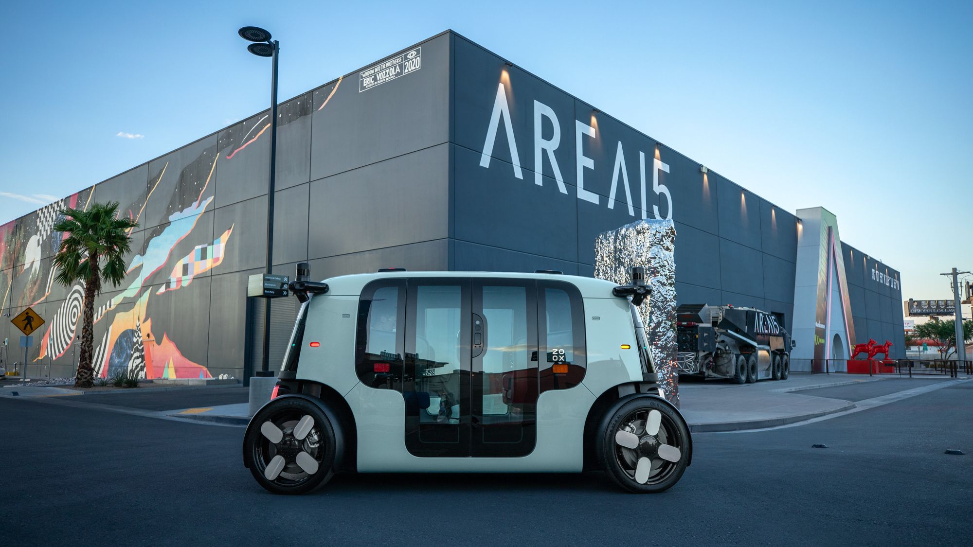 Zoox's toaster-shaped robotaxi parked on street near AREA15 — the award-winning immersive entertainment district just off the Las Vegas Strip.