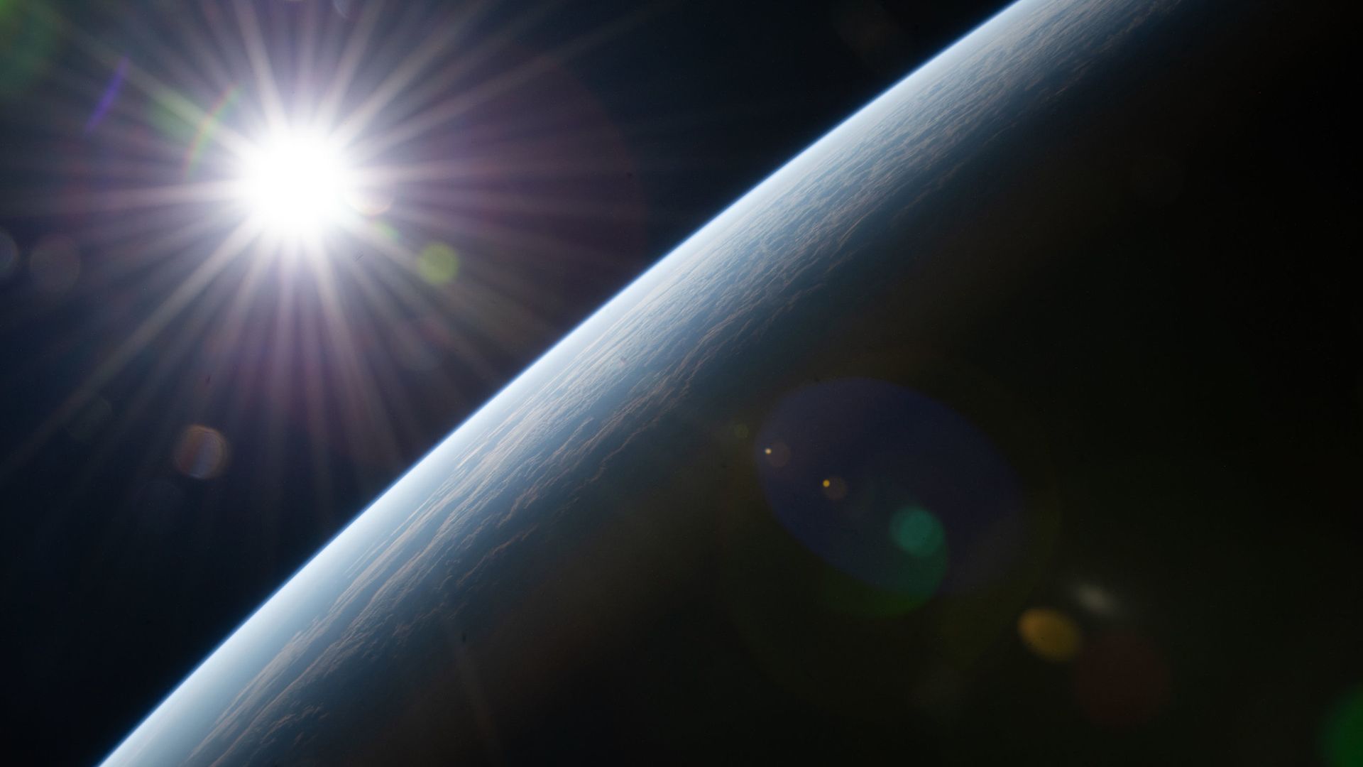 The Sun rises above the Earth from the International Space Station