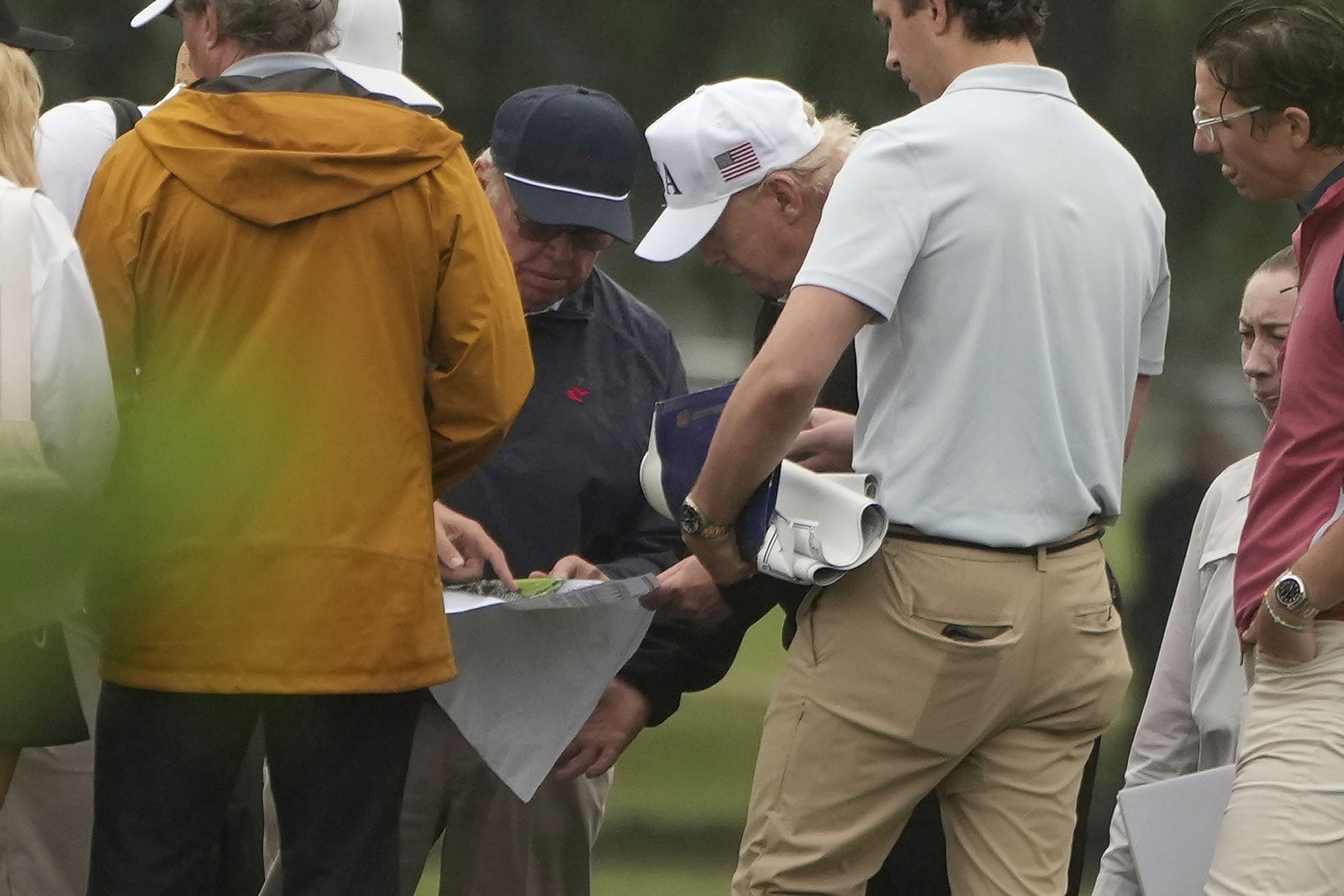 President Donald Trump, center right, looks at blueprints with golf course architect Tom Fazio as they tour the East Potomac Park golf course, Sunday, June 28, 2026, in Washington. (AP Photo/Mark Schiefelbein)