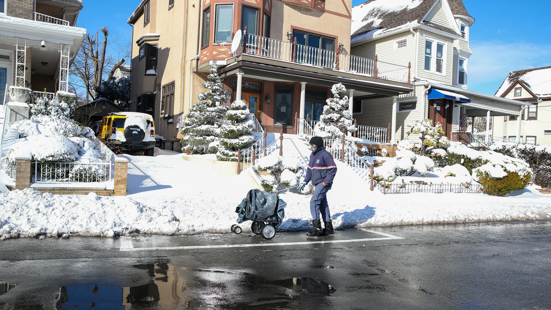 A USPS worker is seen deliver mail in December