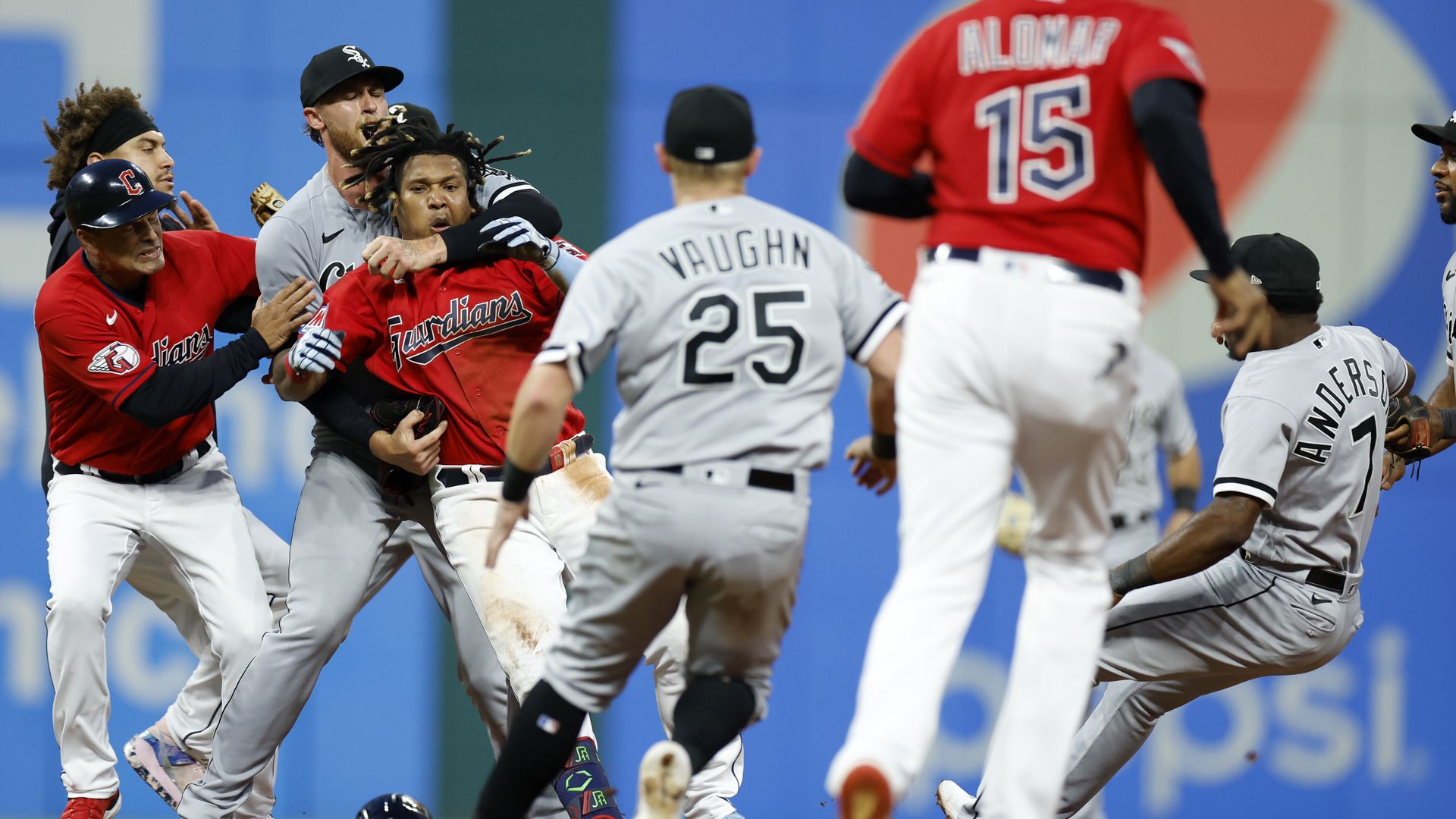 The Guardians' Jose Ramirez is restrained by a White Sox player after punching Tim Anderson