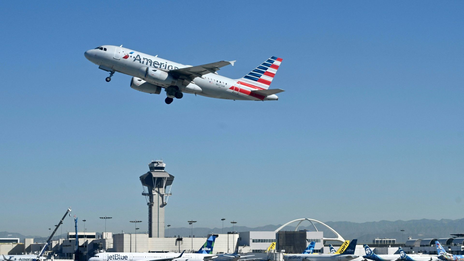 Photo of an American Airlines plane taking off into the sky from an airport