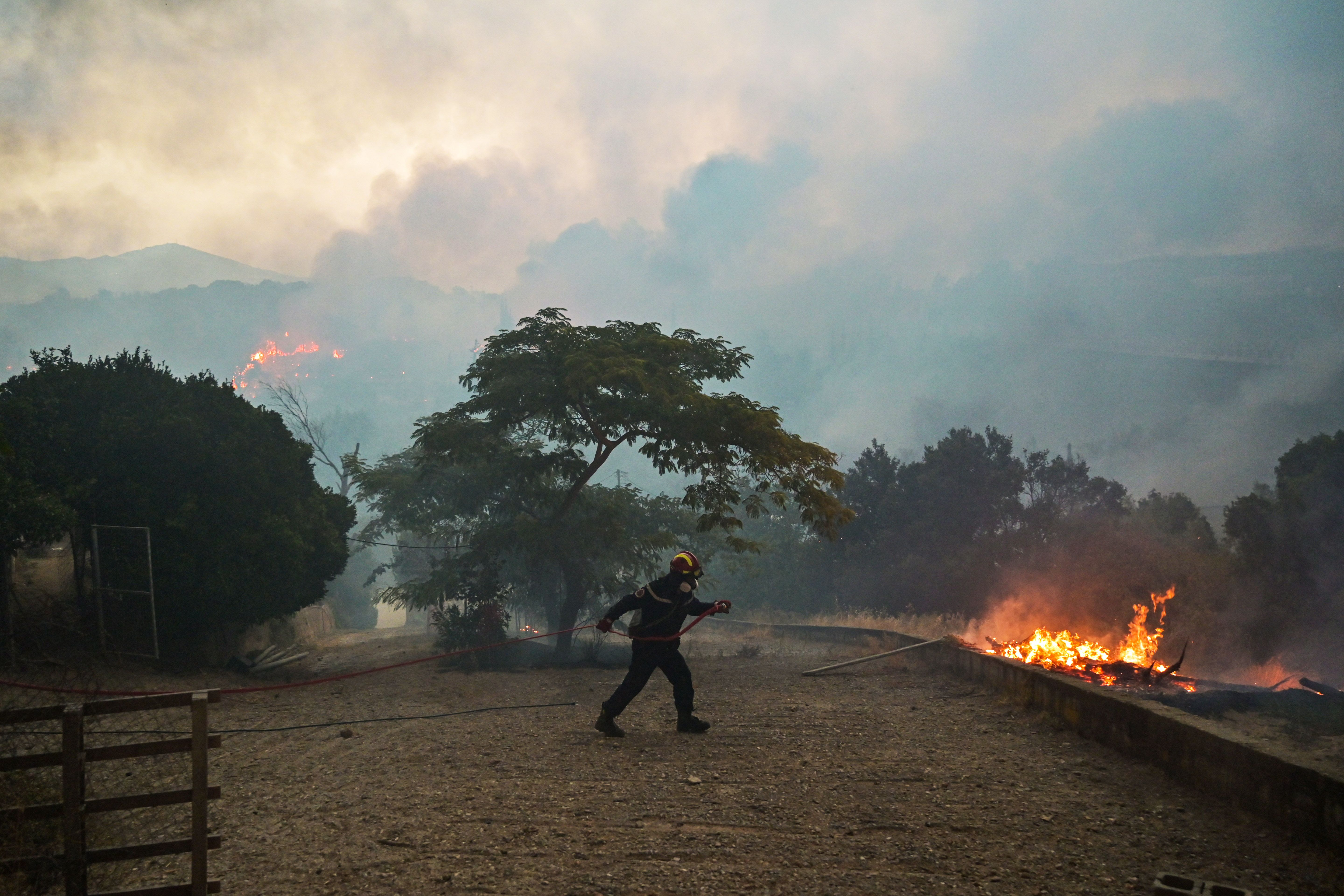 Photo of firefighter walking towards a fire