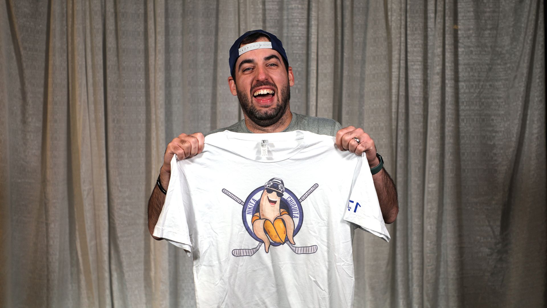 Paul Discoll holds up a shirt.