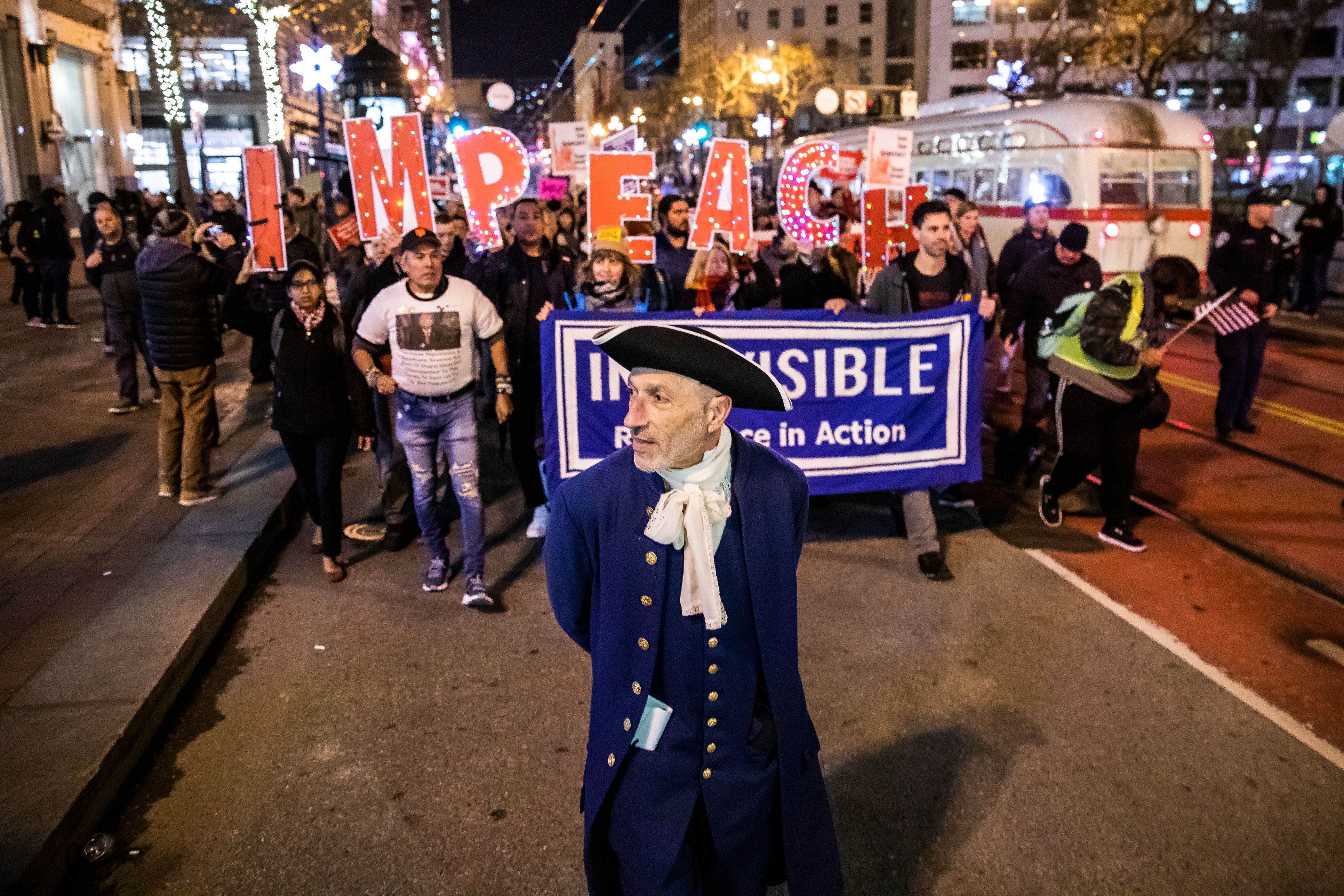 Event organizer Steven Rapport leads fellow protesters while dressed as founding father Alexander Hamilton during a demonstration in San Francisco. 