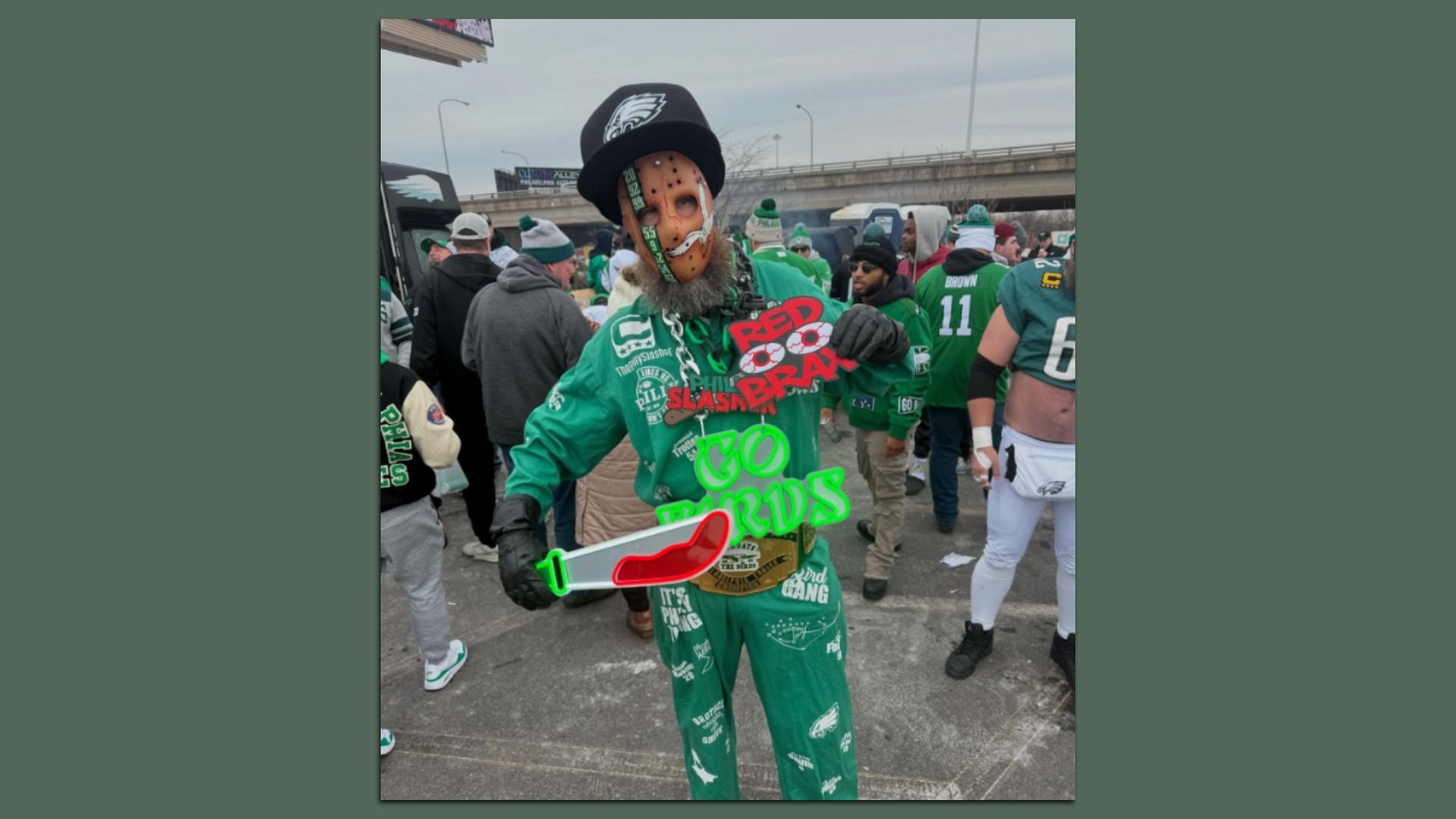 An Eagles fan in a green sweatsuit, sporting a "Friday the 13th"-esque slasher mask and a giant Eagles hat.
