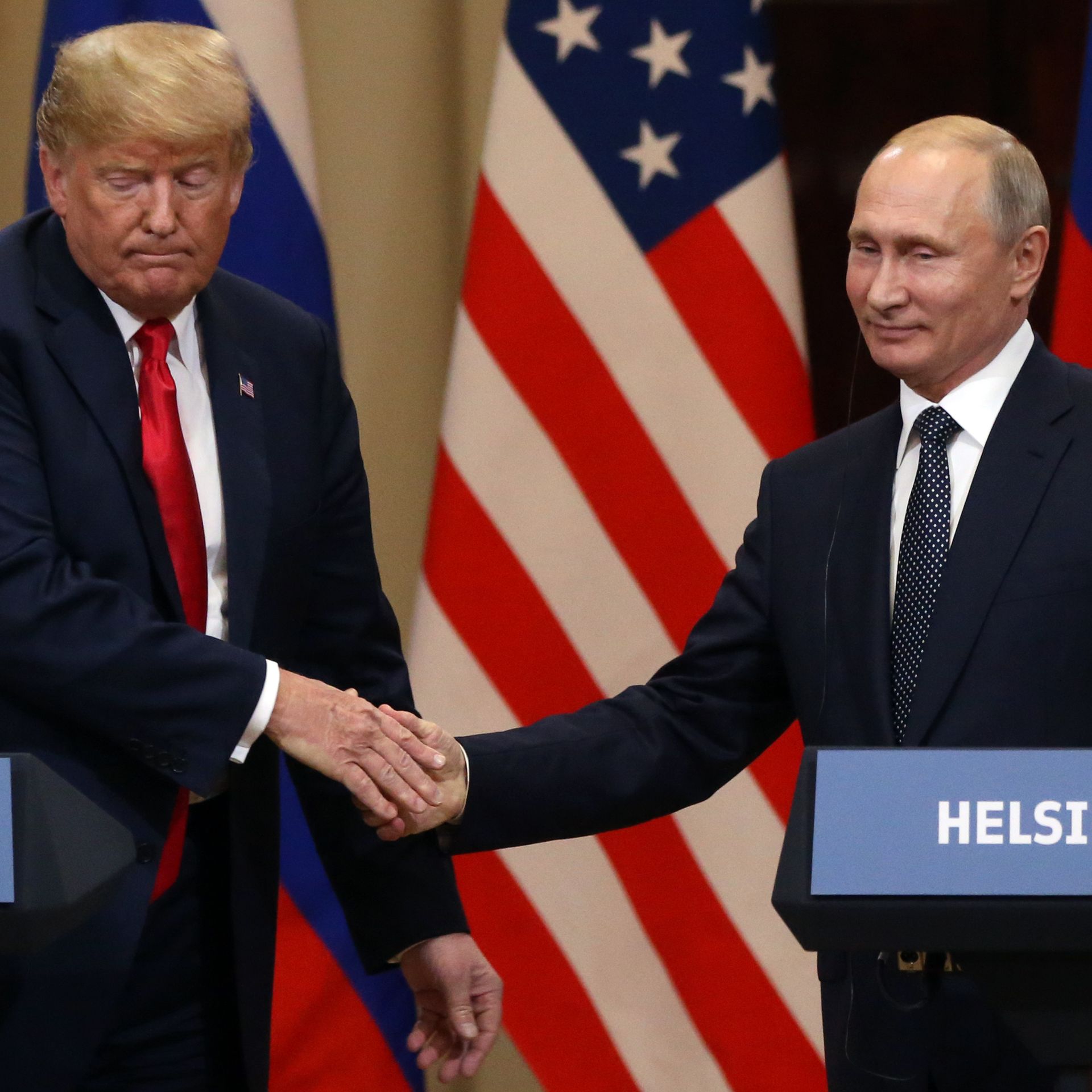Trump and Putin shake hands while standing at podiums for press conference