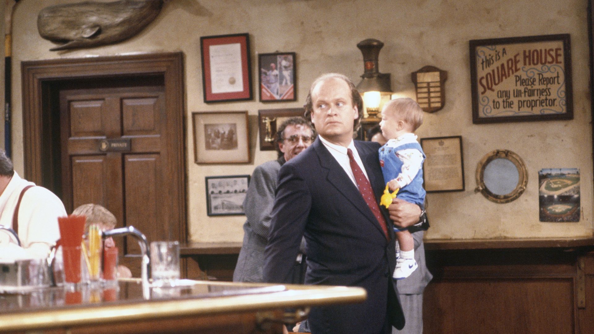 Dr. Frasier Crane on Cheers holding a baby in the Cheers bar on Episode 7, "Breaking in is hard to do."