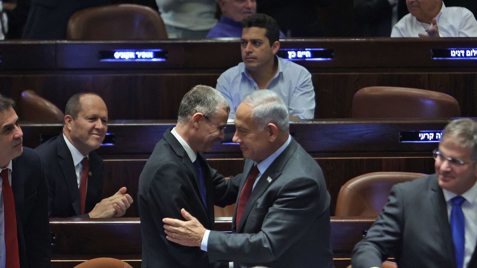 Temporary Knesset (Israeli parliament) speaker Yariv Levin (C-L) greets prime minister-designate Benjamin Netanyahu 