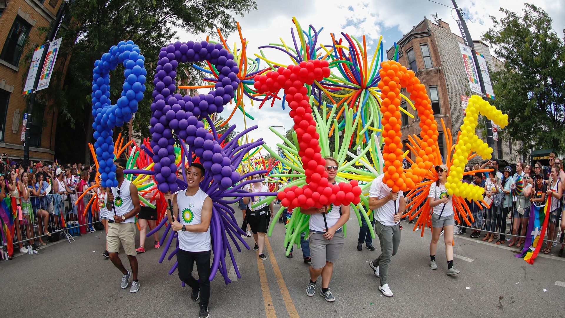 People march in a parade with balloons. 