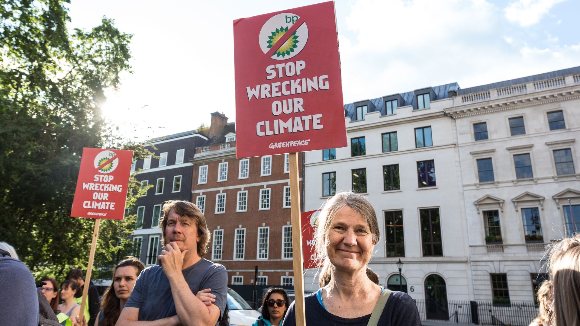 Woman with sign that says "BP stop wrecking our climate"