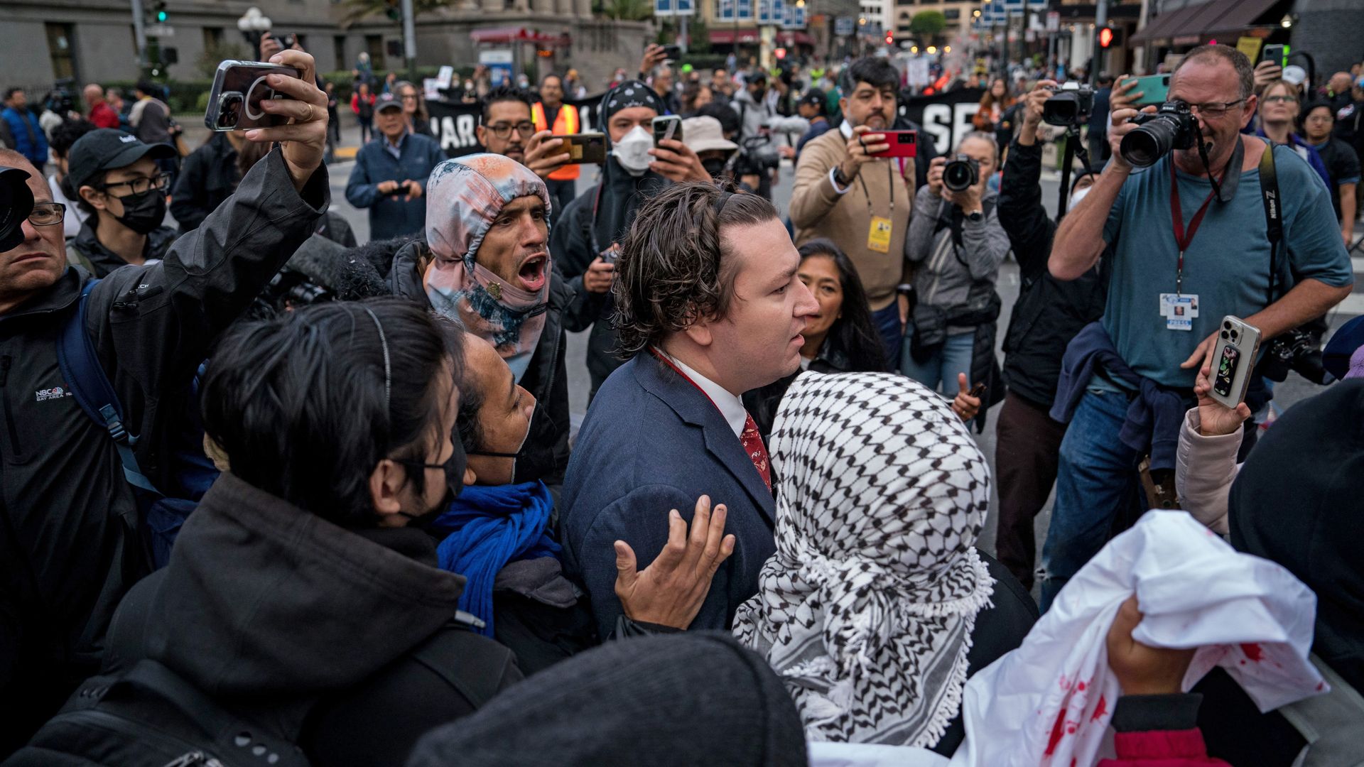 Photo of protesters yelling at a delegate on the streets
