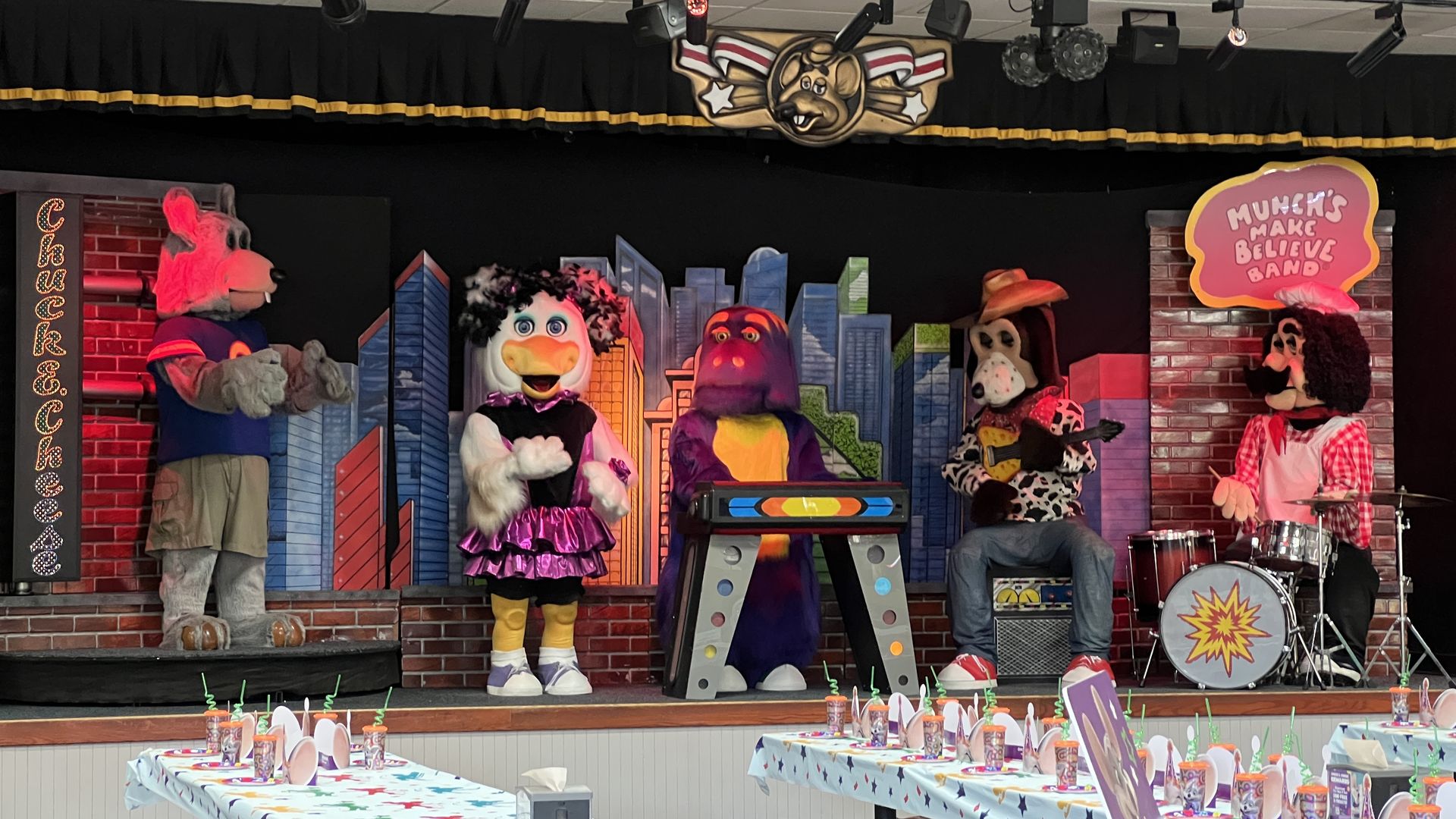 Animatronic rat characters sing songs on a stage