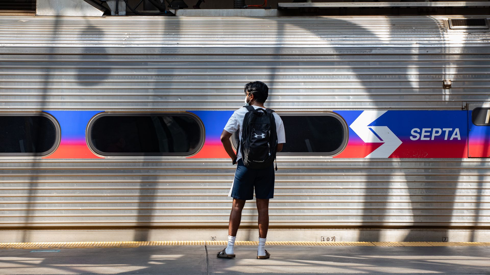 A man stands in front of a SEPTA train.