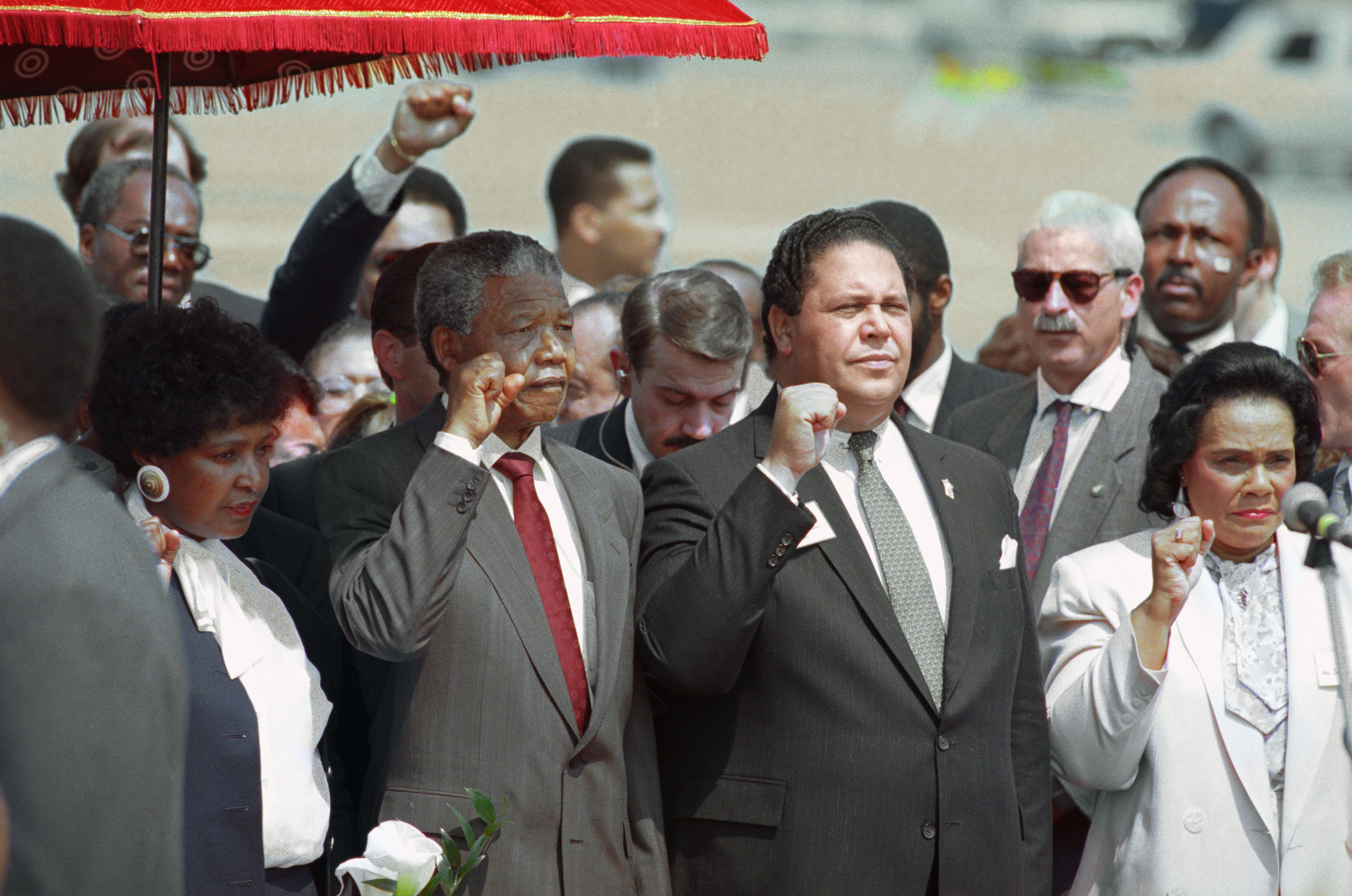 Atlanta Mayor Maynard Jackson (centre) and Coretta Scott King, widow of slain civil rights leader Dr. Martin Luther King, Jr., join Nelson Mandela in holding up clenched fists during the playing of the Anthem of Mandela's African National Congress on Mandela's arrival in Atlanta, Georgia.