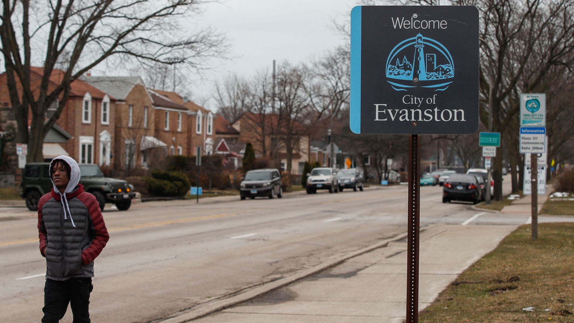 A man walks by a sign welcoming people to the city of in Evanston, Illinois, on March 16