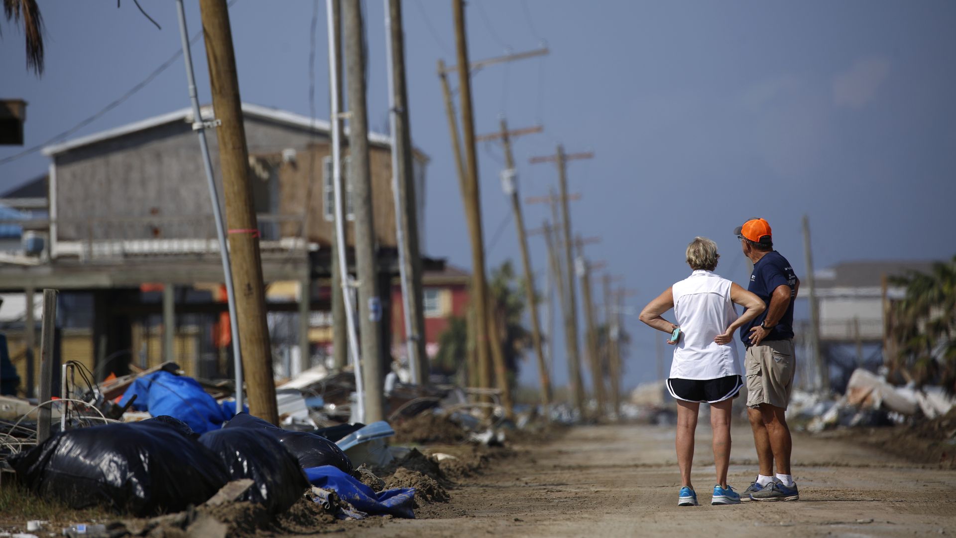 Residents look at hurricane damage to homes and power lines.