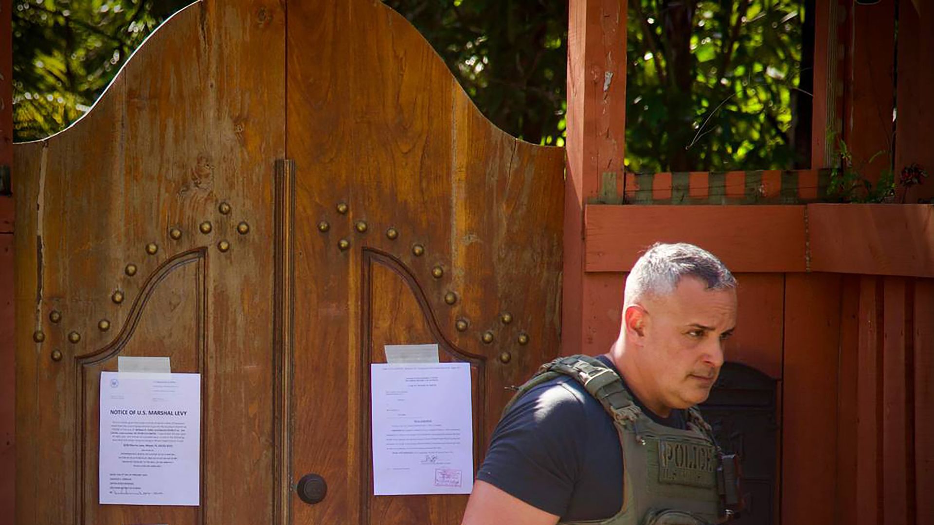 A US Marshall walks away from the front door to Joe Carollo's residence in Coconut Grove after posting notices on Friday, Feb. 2, 2024. Carollo, a Miami commissioner, lost a civil trial accusing him of misusing his public office and was hit with a $63 million judgment. 