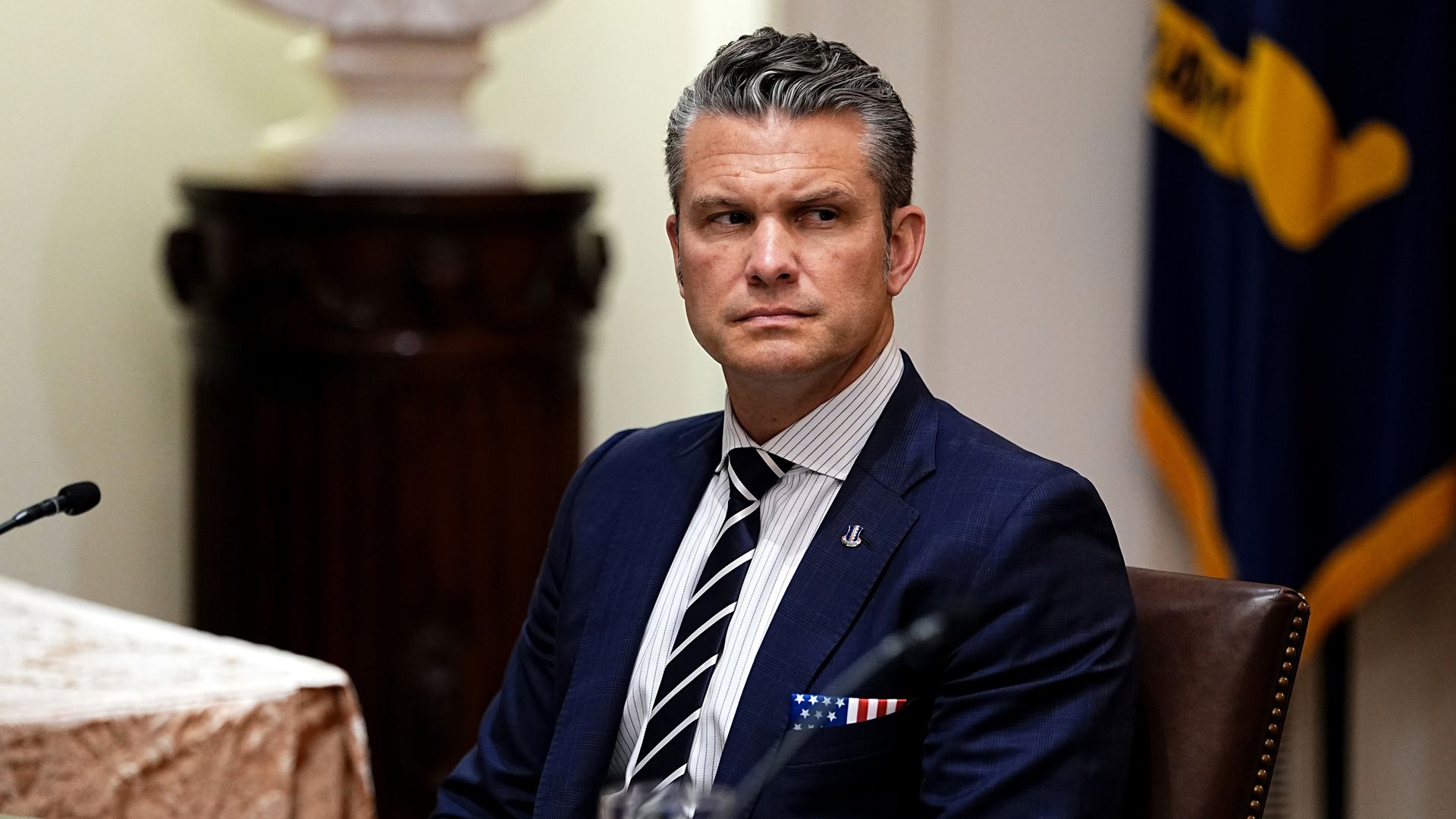 Pete Hegseth seated in the White House Cabinet Room, flanked by staff, during a meeting with President Trump and visiting Hungarian Prime Minister Viktor Orbán.