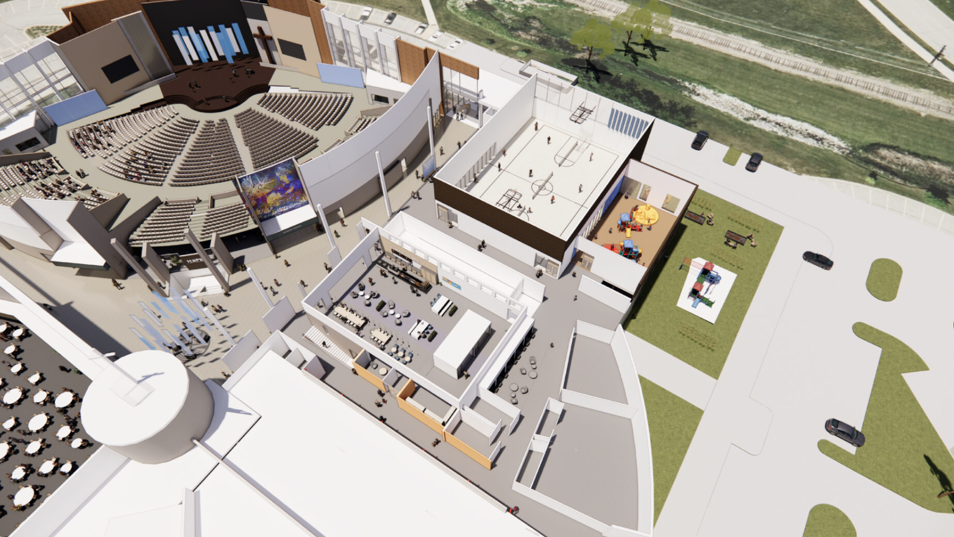 Bird's-eye 3D view of a modern campus building with a large curved auditorium, multiple interior levels including offices and a cafe, rooftop gym, playground, green lawns, and surrounding roads.