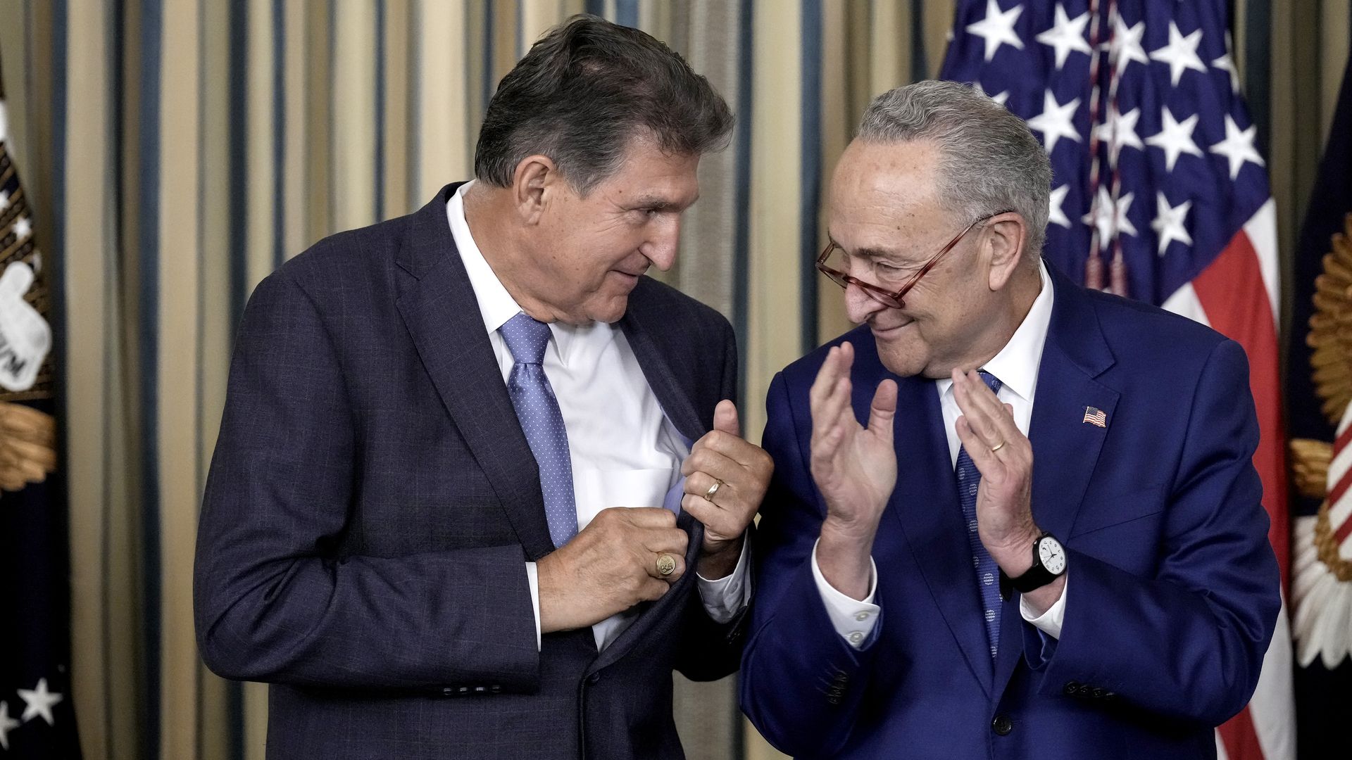 Sen. Joe Manchin (D-WV) looks to Senate Majority Leader Chuck Schumer (D-NY) after U.S. President Joe Biden signs The Inflation Reduction Act in the State Dining Room of the White House August 16, 2022 in Washington, DC.