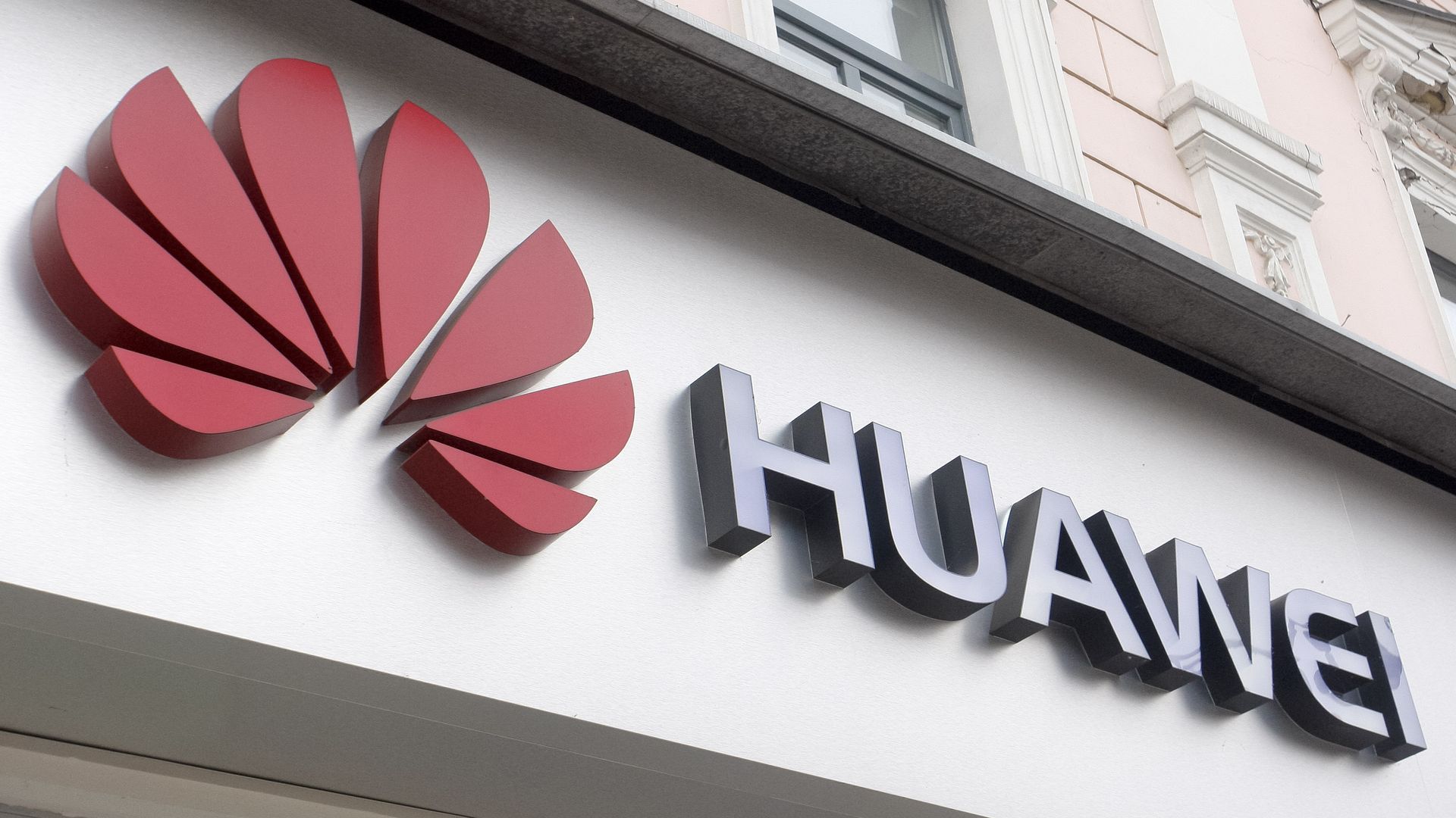 The Huawei logo affixed to a buiding. 