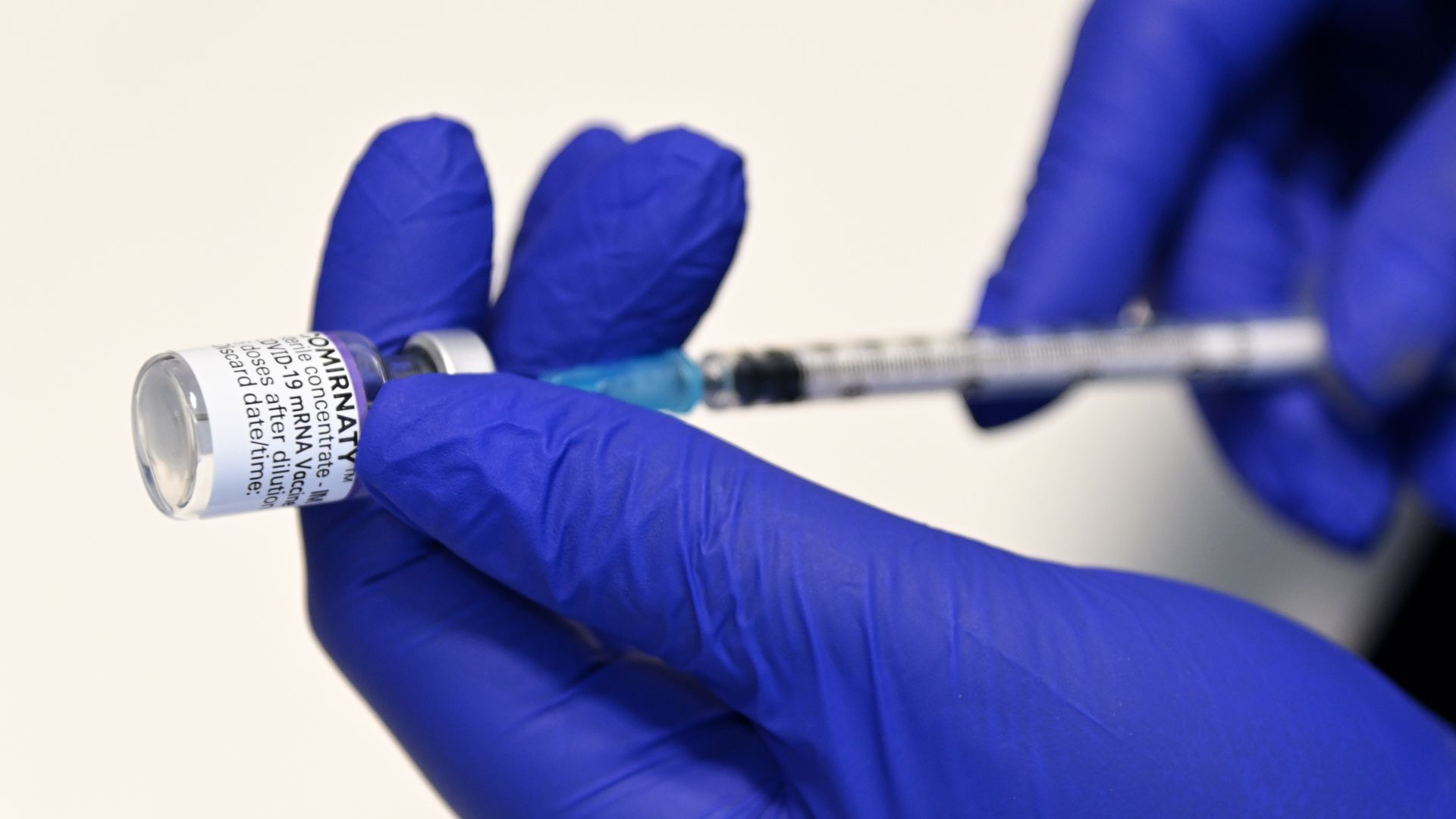A pharmacist prepares to give a COVID-19 booster vaccination