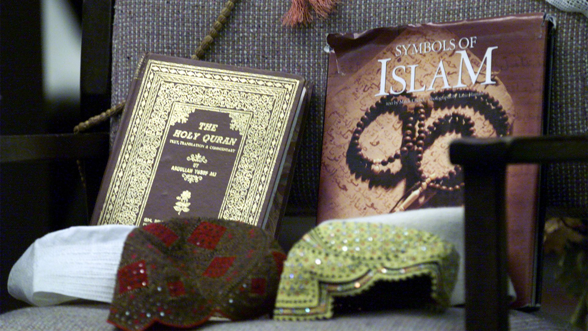 Photo of a copy of the Quran sitting on a chair next to a book titled "Symbols of Islam"