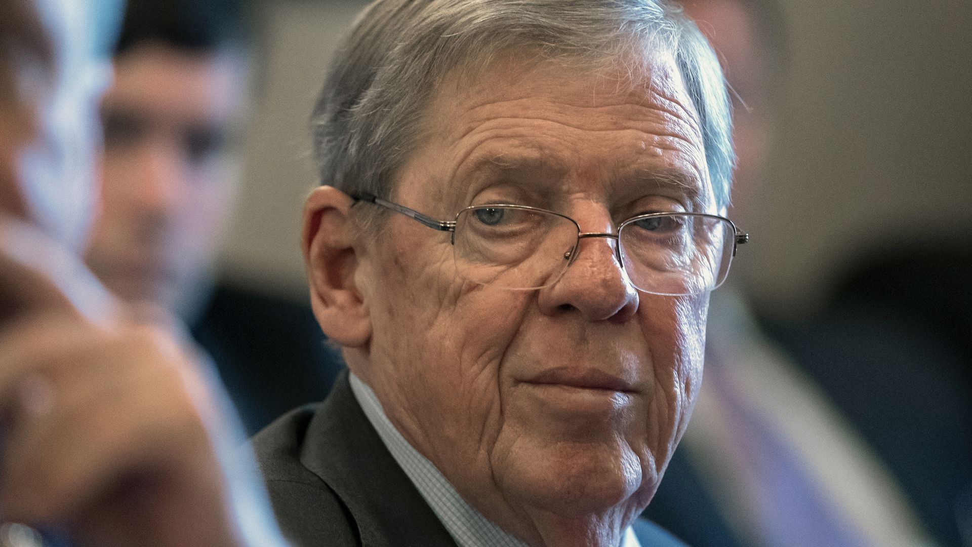 Johnny Isakson sits in a meeting and looks toward the camera