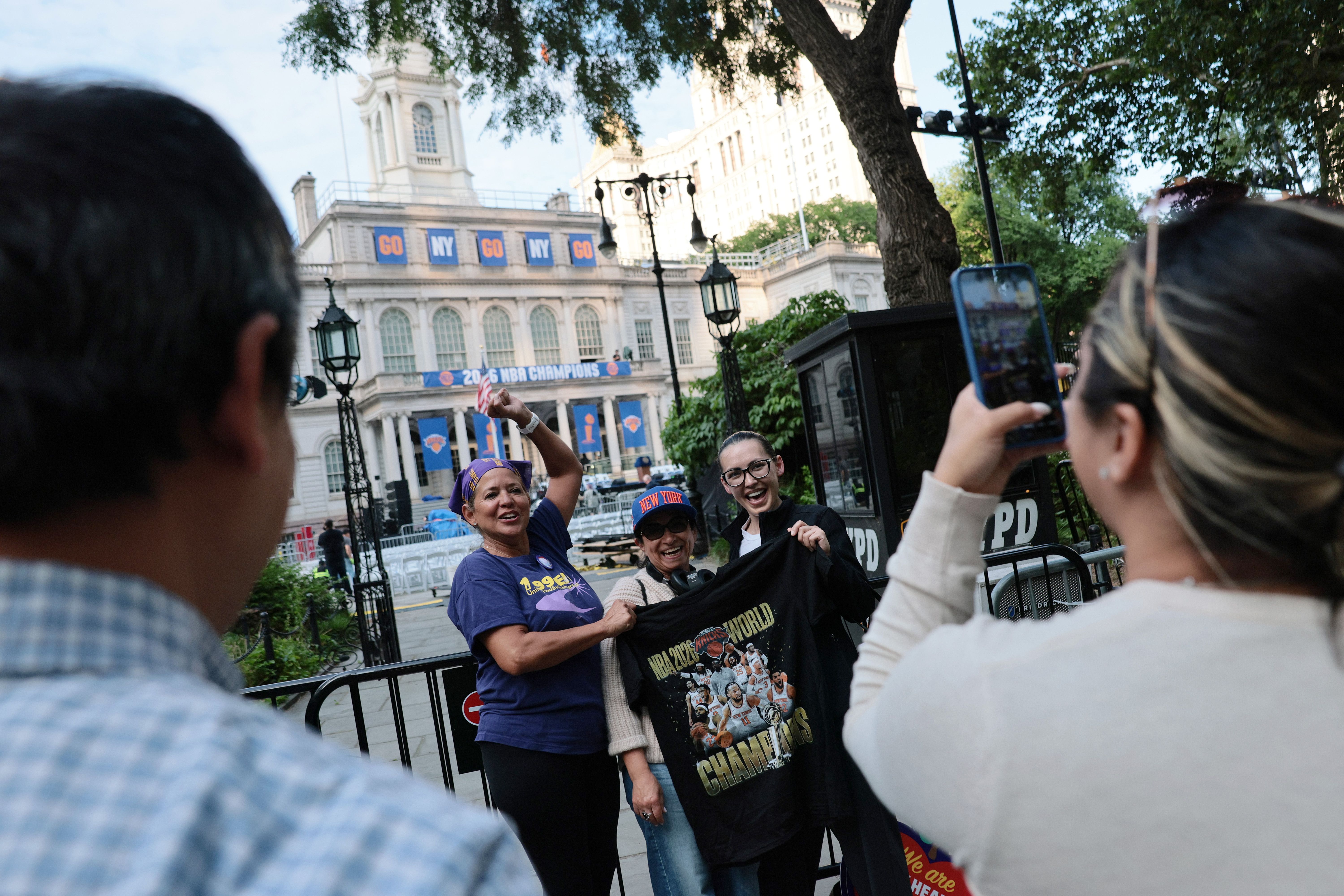Knicks fans take pictures outside City Hall yesterday before the parade.