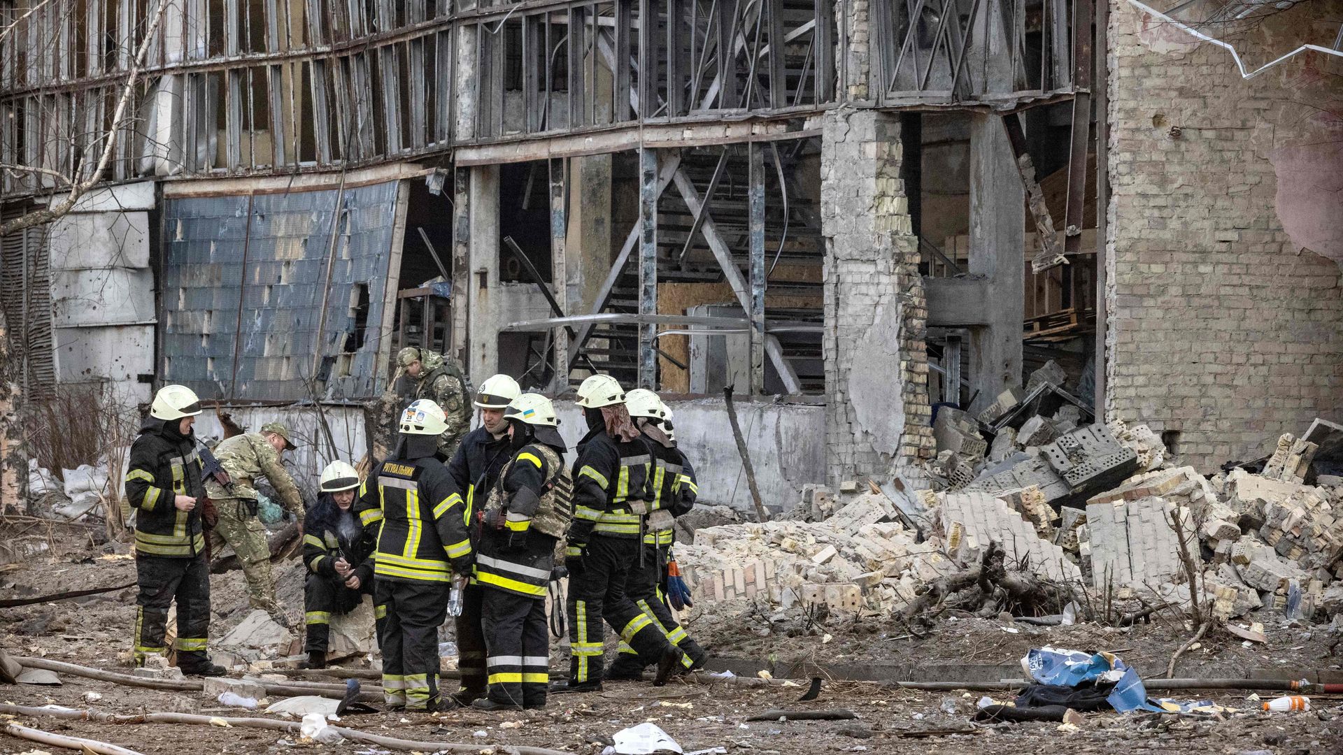 Firefighters sit amid debris in the area of a research institute, part of Ukraine's National Academy of Science, after a strike by drones that killed at least one, in northwestern Kyiv, on March 22.