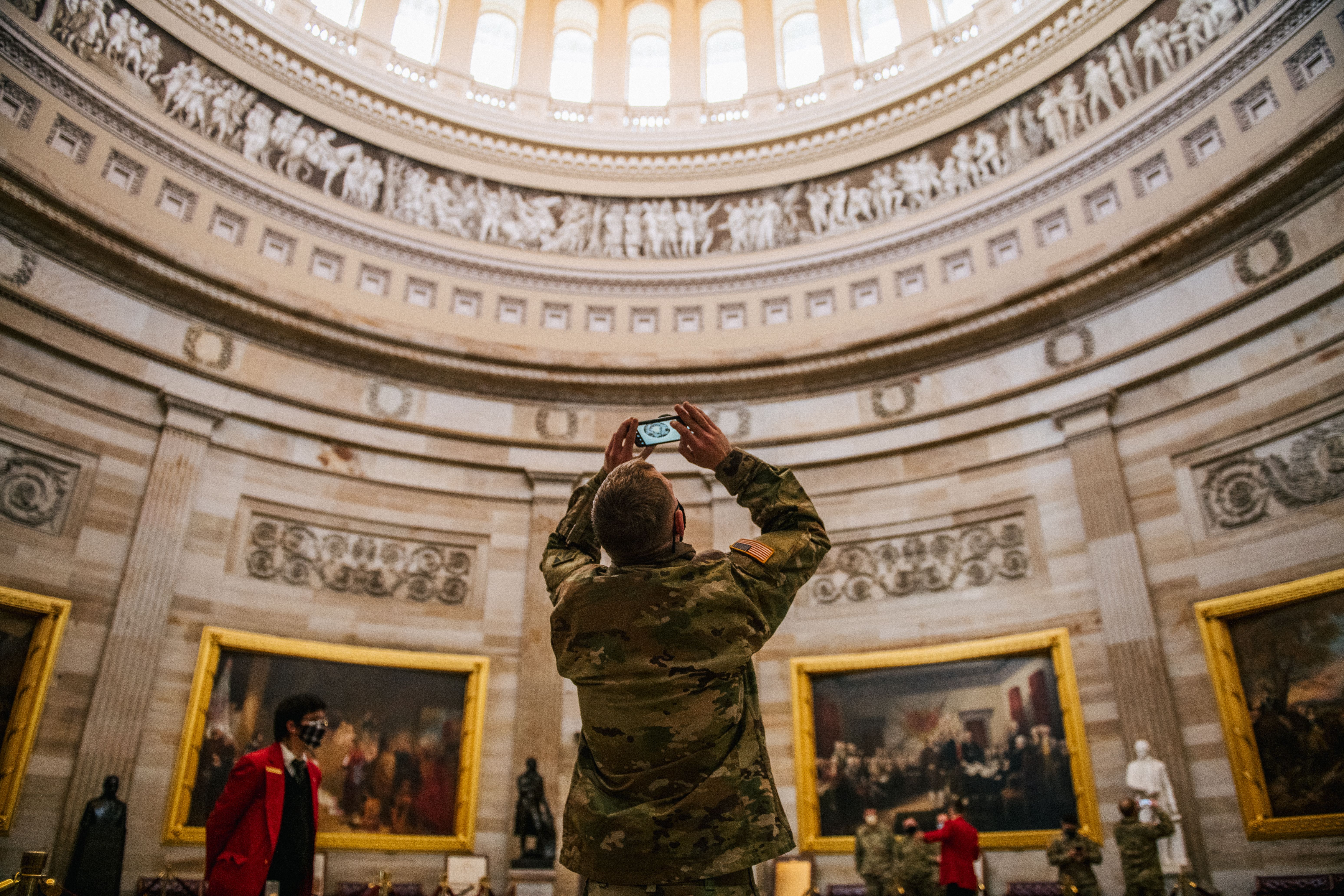 A person takes photos inside the Capitol rotunda.