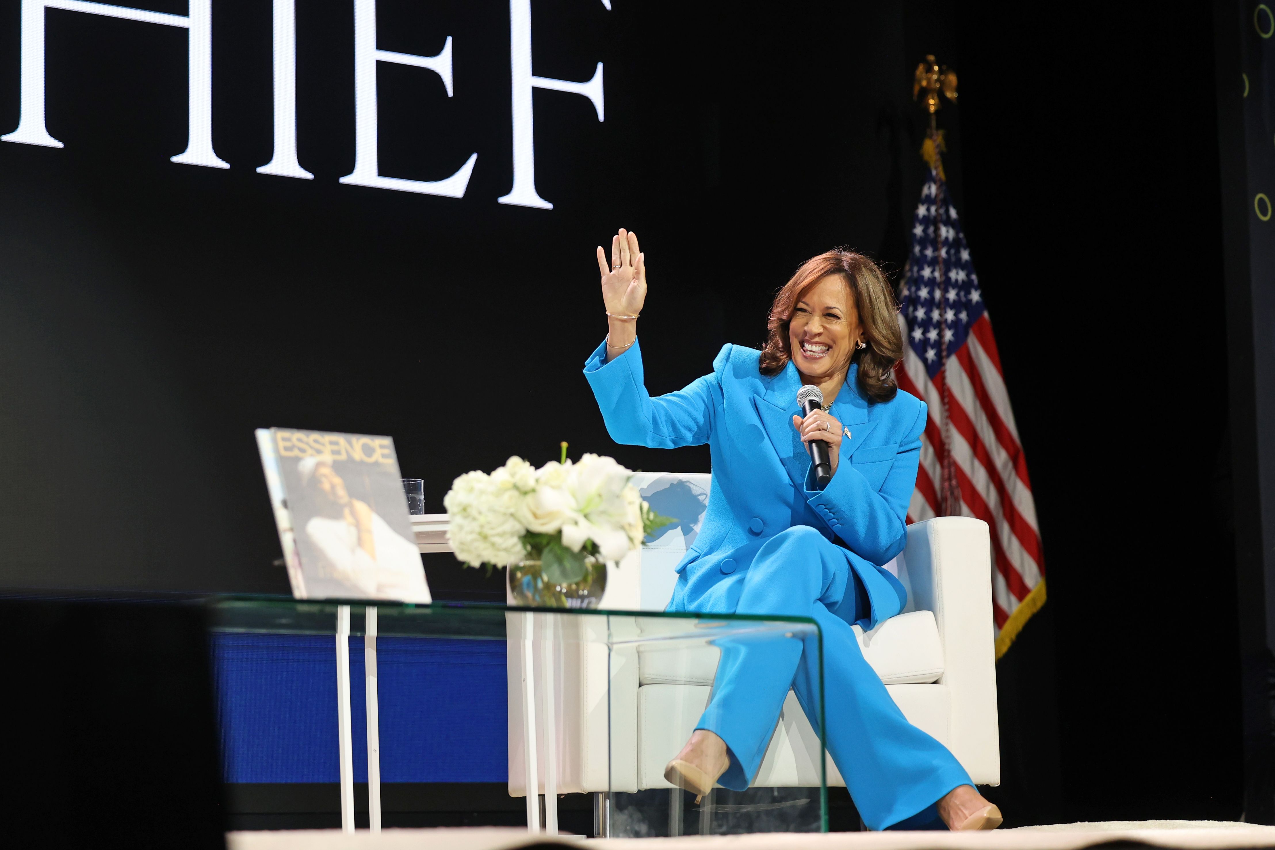 Photo shows Kamala Harris on stage in a blue suit.